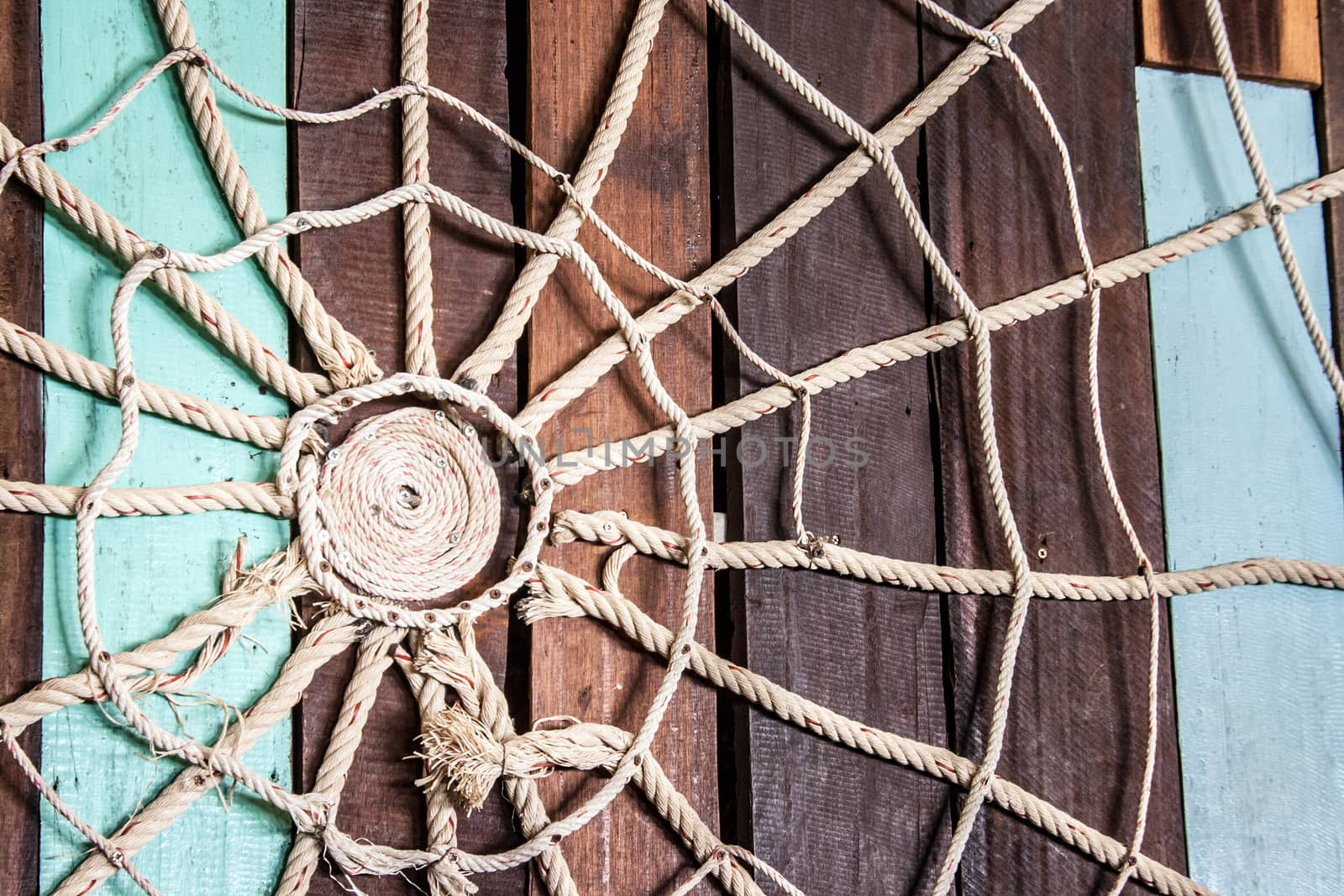 Spider web made of rope on the wood wall