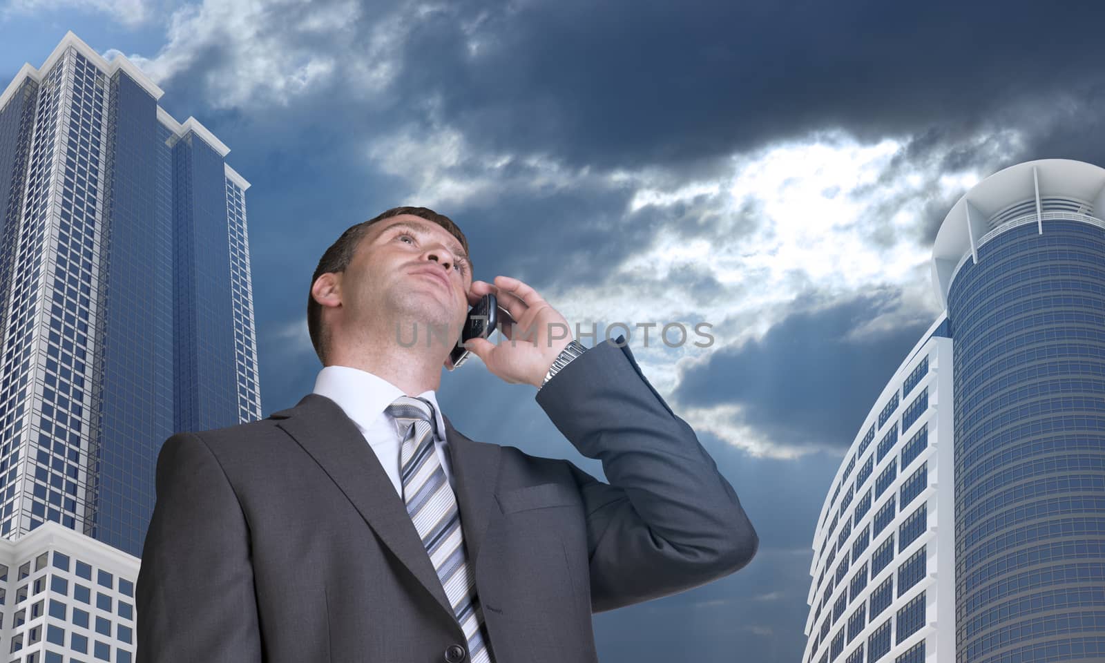 Businessman talking on the phone. Skyscrapers and clouds in background