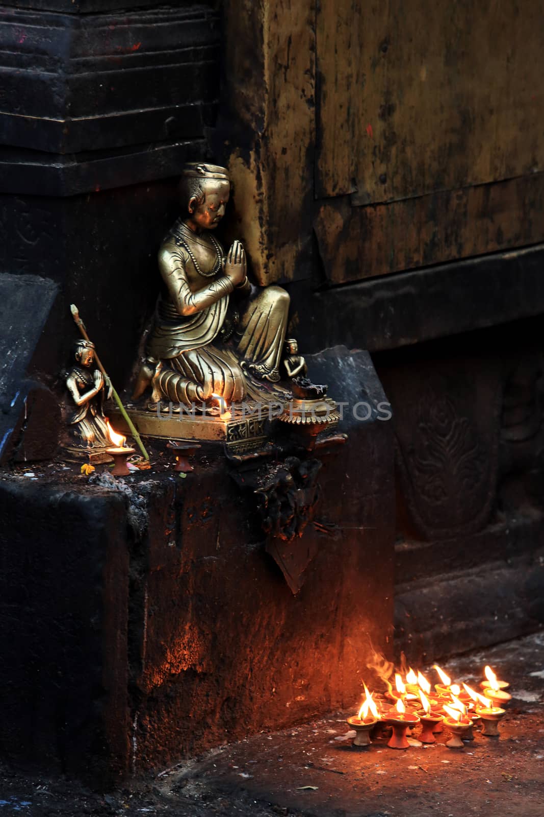 Buddha with candles in the Swayambhunath Stupa, Kathmandu, Nepal