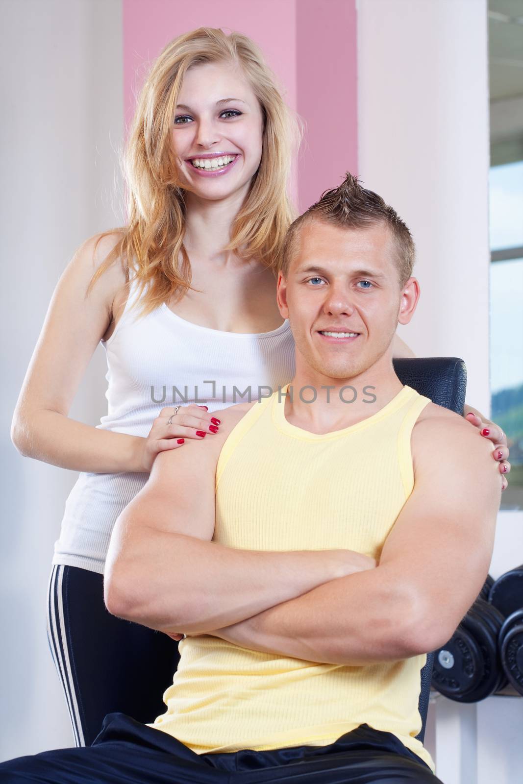 portrait of fit young woman and man in modern gym