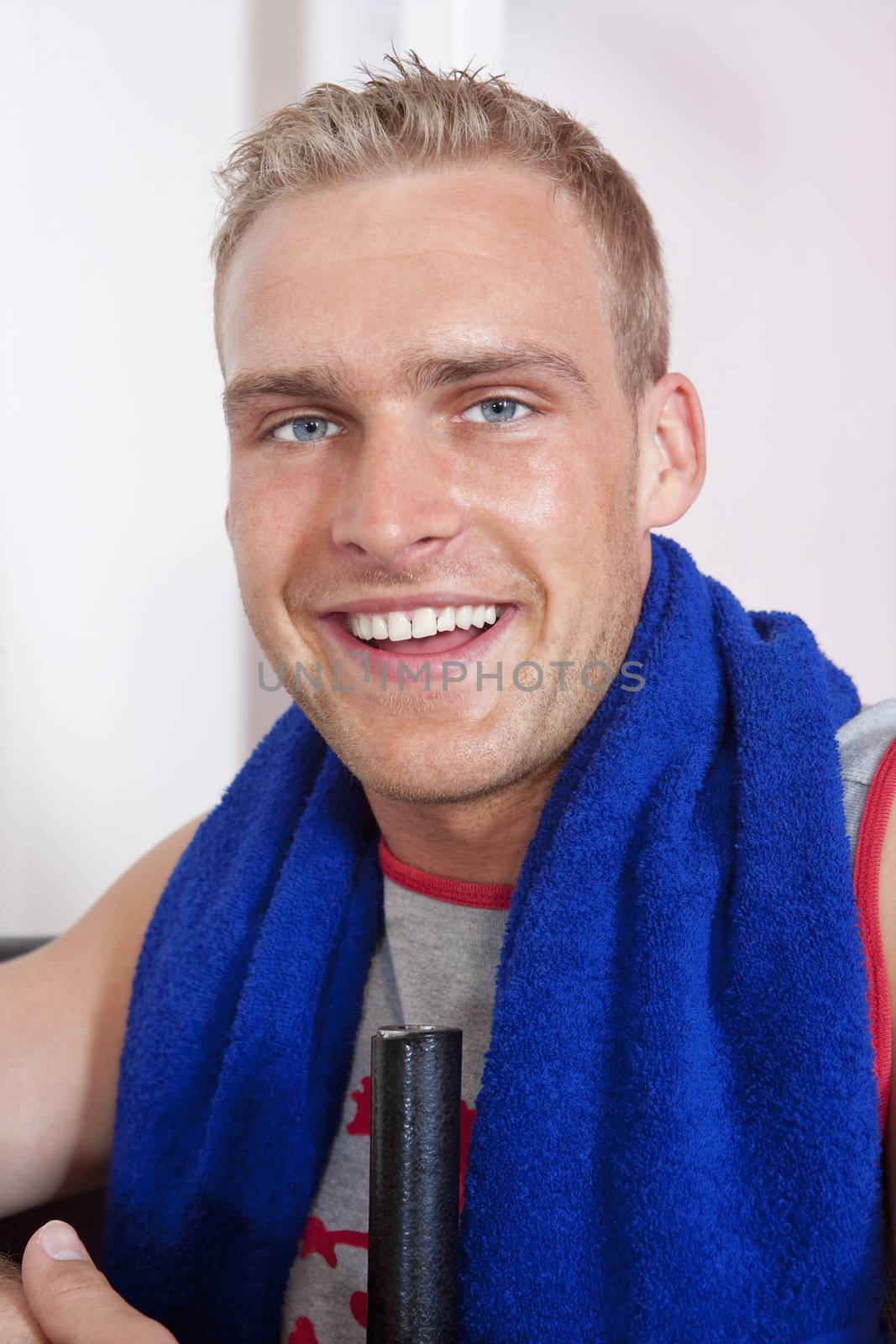 portrait of a young man with towel in modern gym