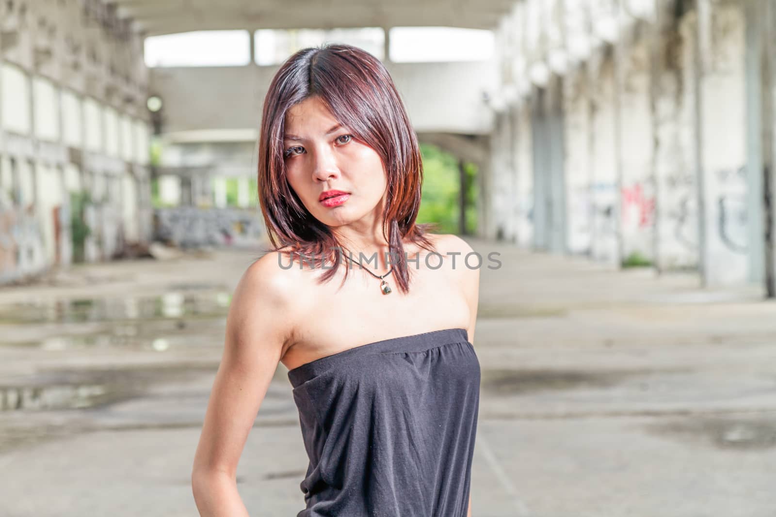Chinese woman standing in abandoned building by imagesbykenny