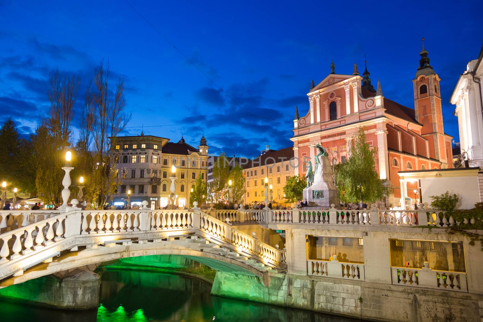 Romantic Ljubljana's city center at dusk. River Ljubljanica, Triple Bridge, Preseren square and Franciscan Church of the Annunciation. Ljubljana, Slovenia, Europe. 