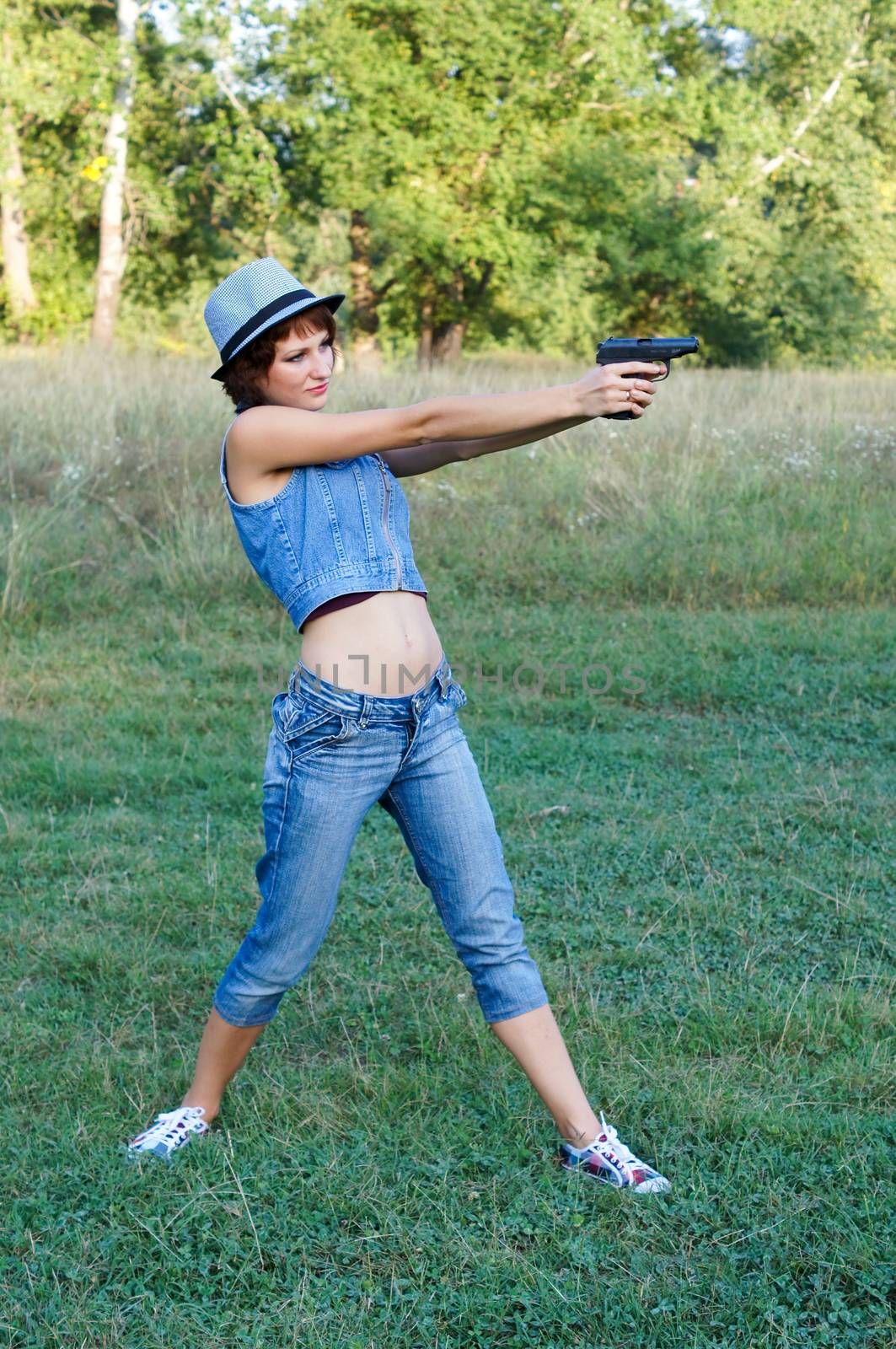 The girl in a hat with a pistol