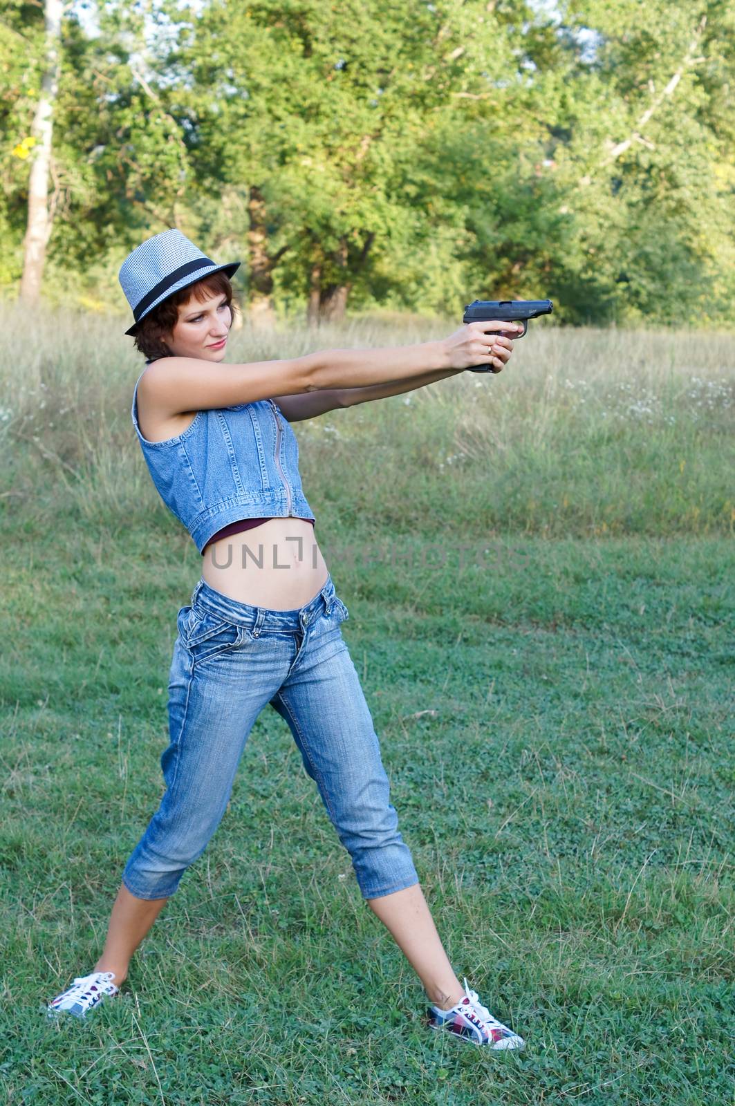 The girl in a hat with a pistol