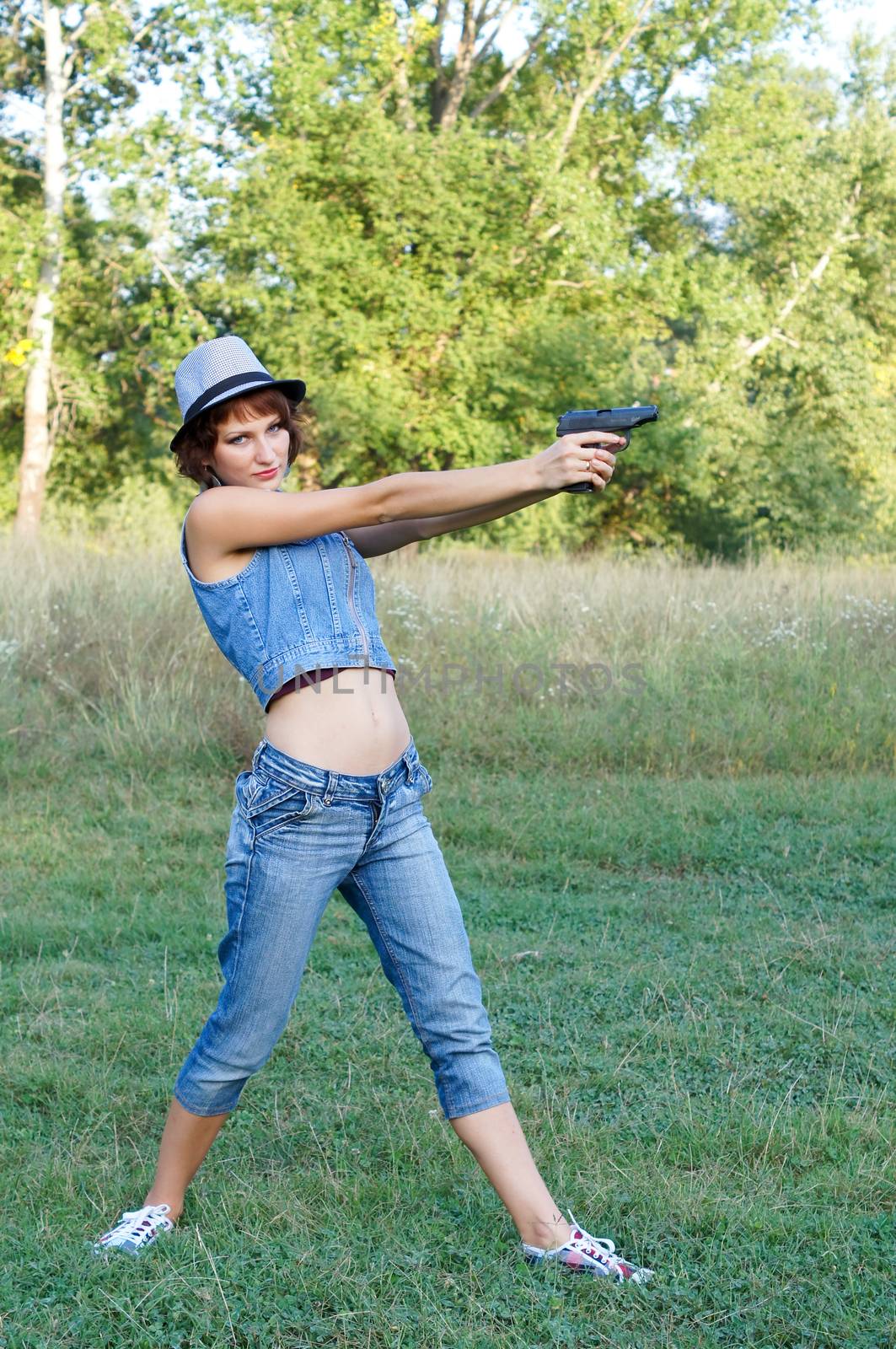 The girl in a hat with a pistol