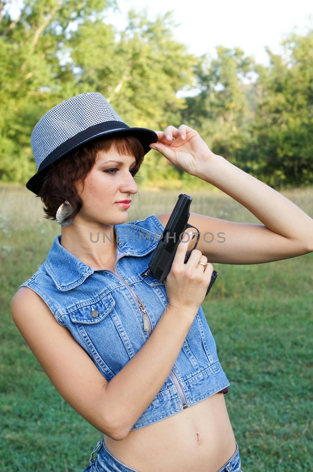 The girl in a hat with a pistol