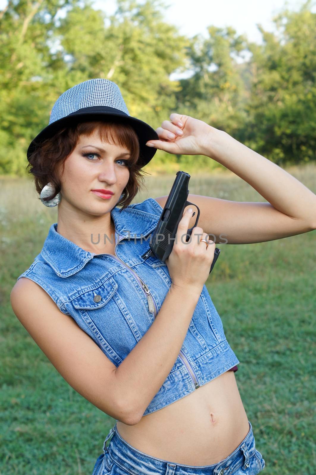 The girl in a hat with a pistol