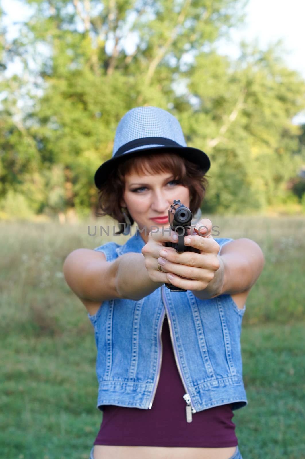 The girl in a hat with a pistol