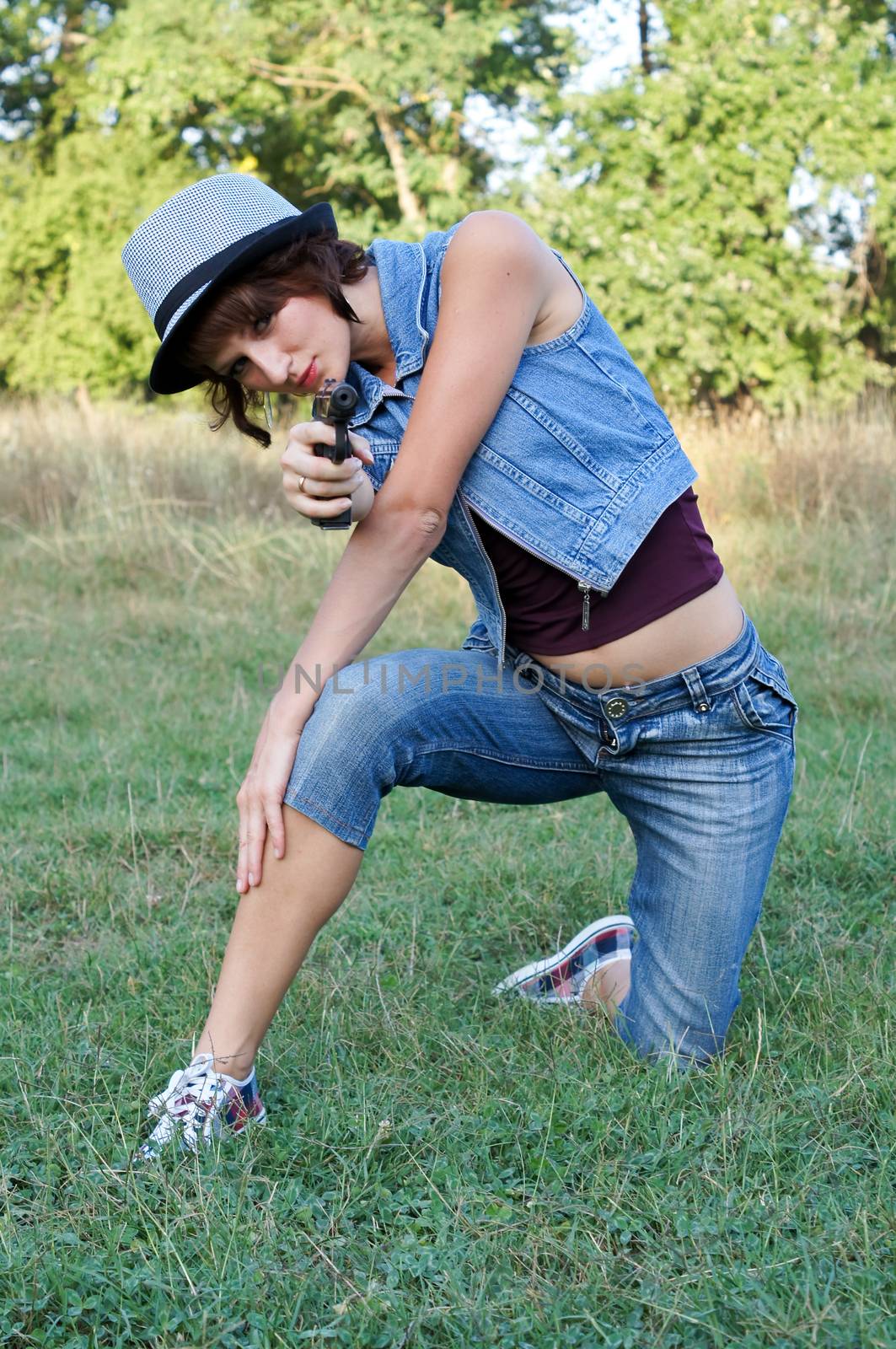 The girl in a hat with a pistol