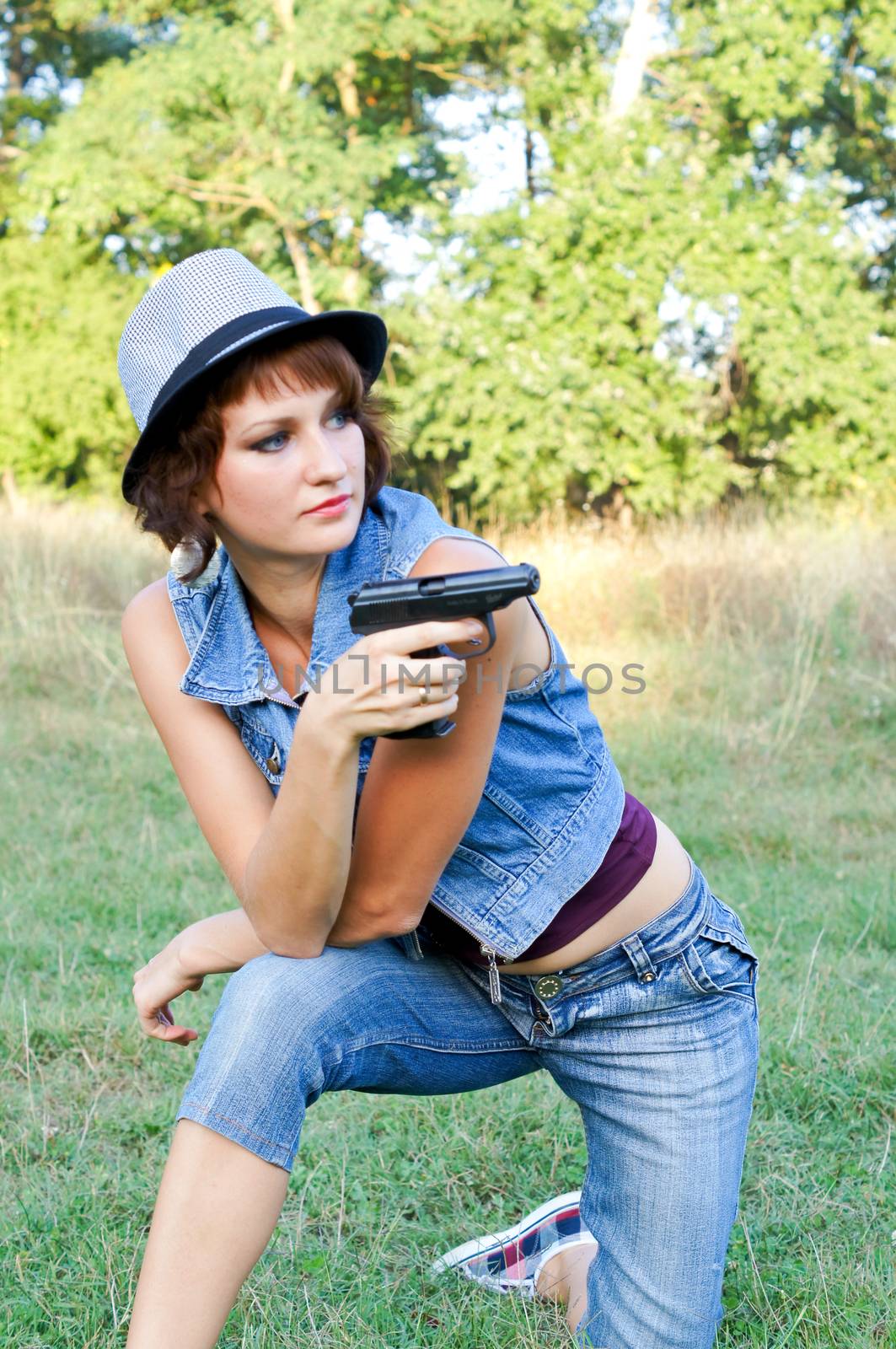 The girl in a hat with a pistol