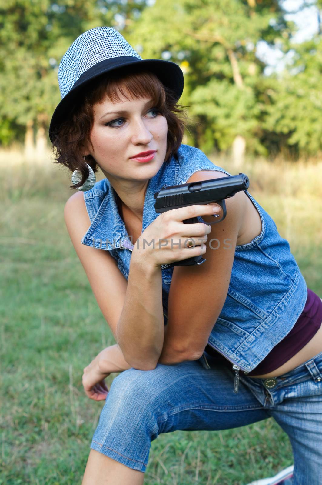 The girl in a hat with a pistol