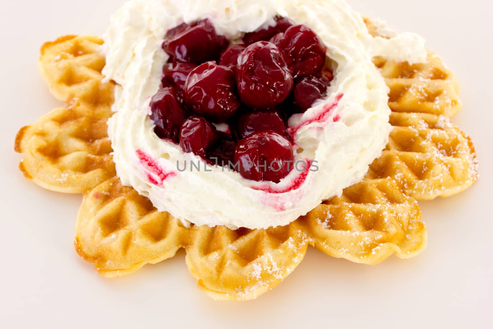 Cream and sour cherries on fresh baked waffle