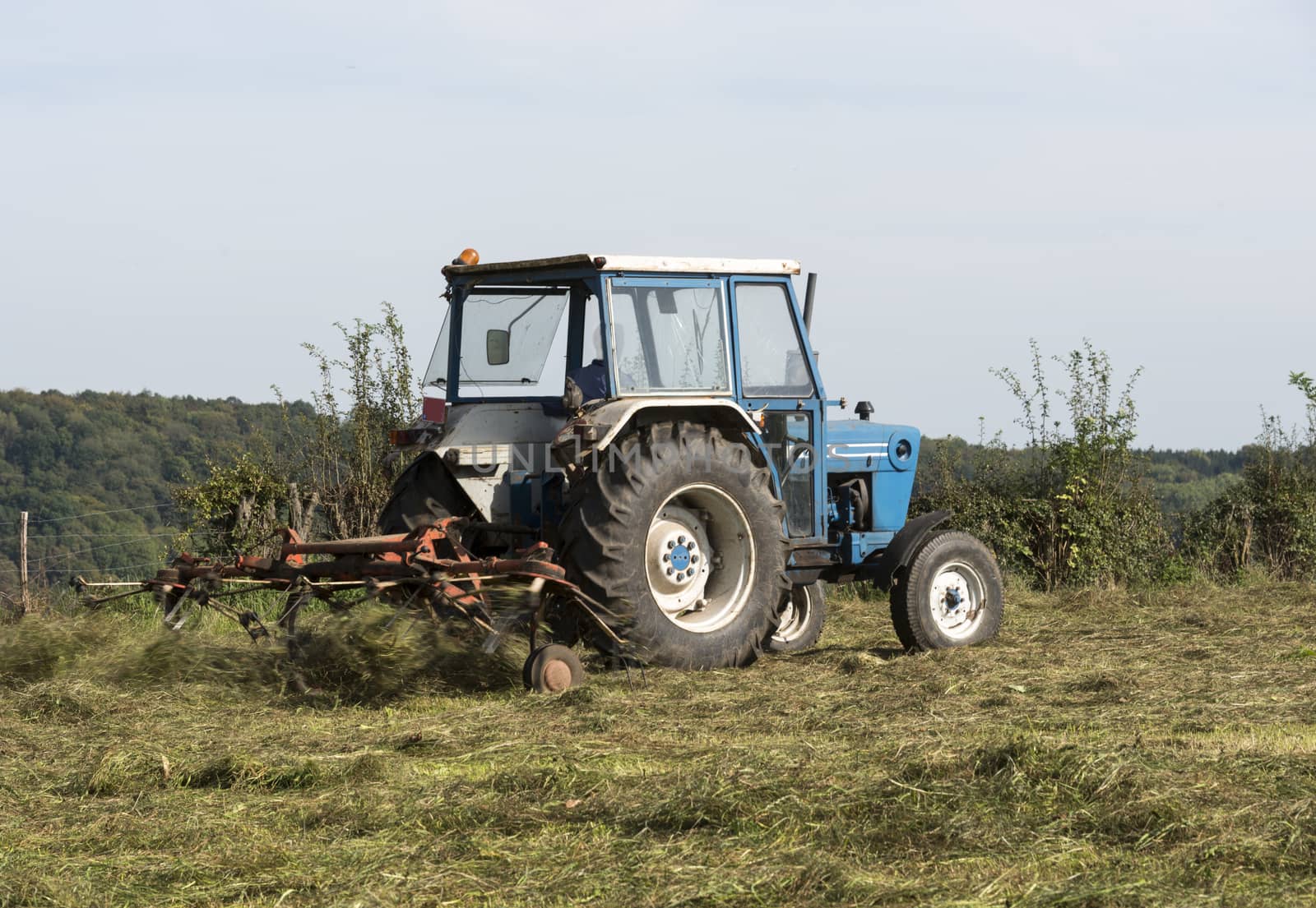 farmer at work with tractor mowing grass