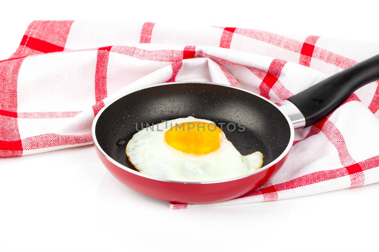 Fried egg in a frying pan, over white background