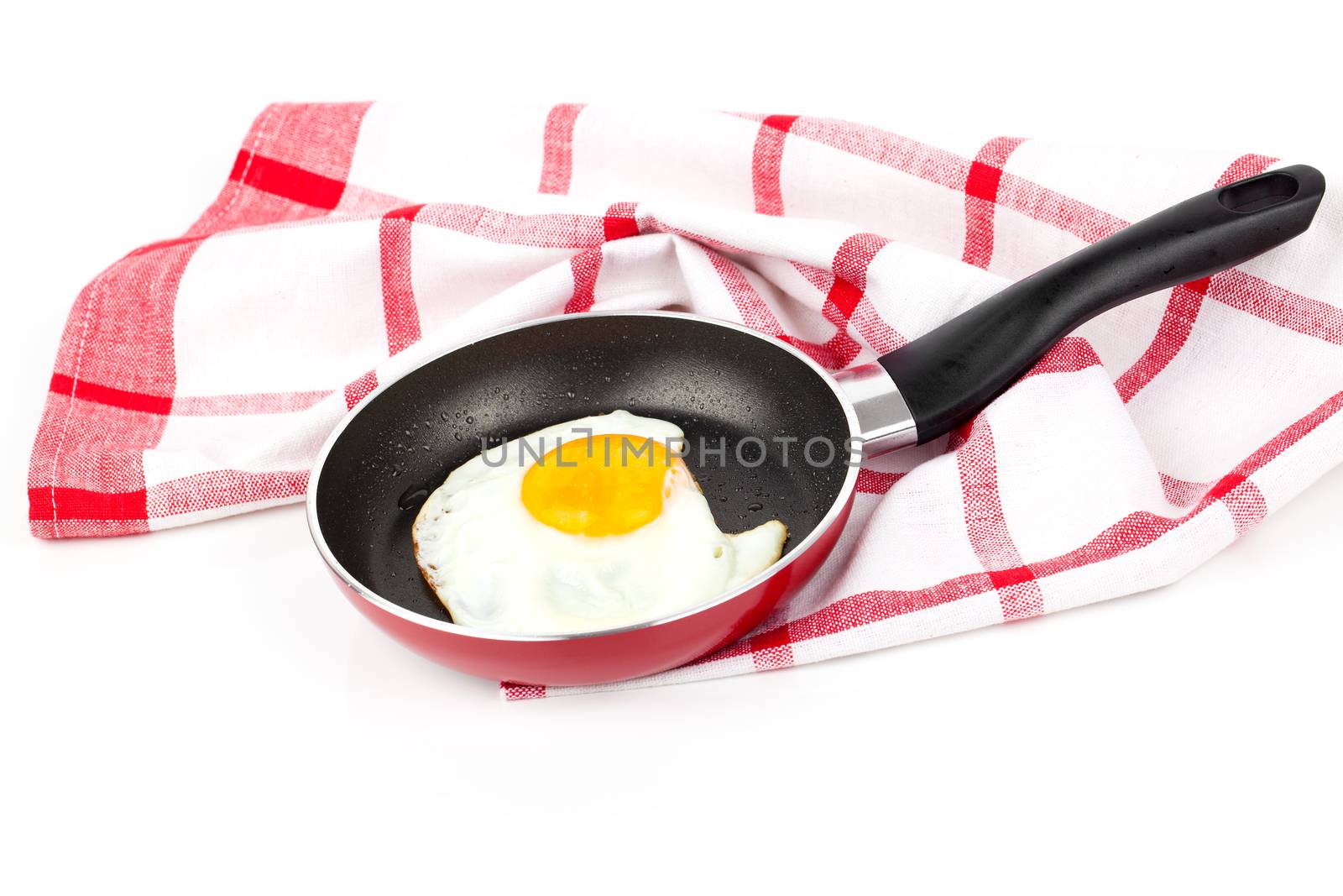 Fried egg in a frying pan, over white background