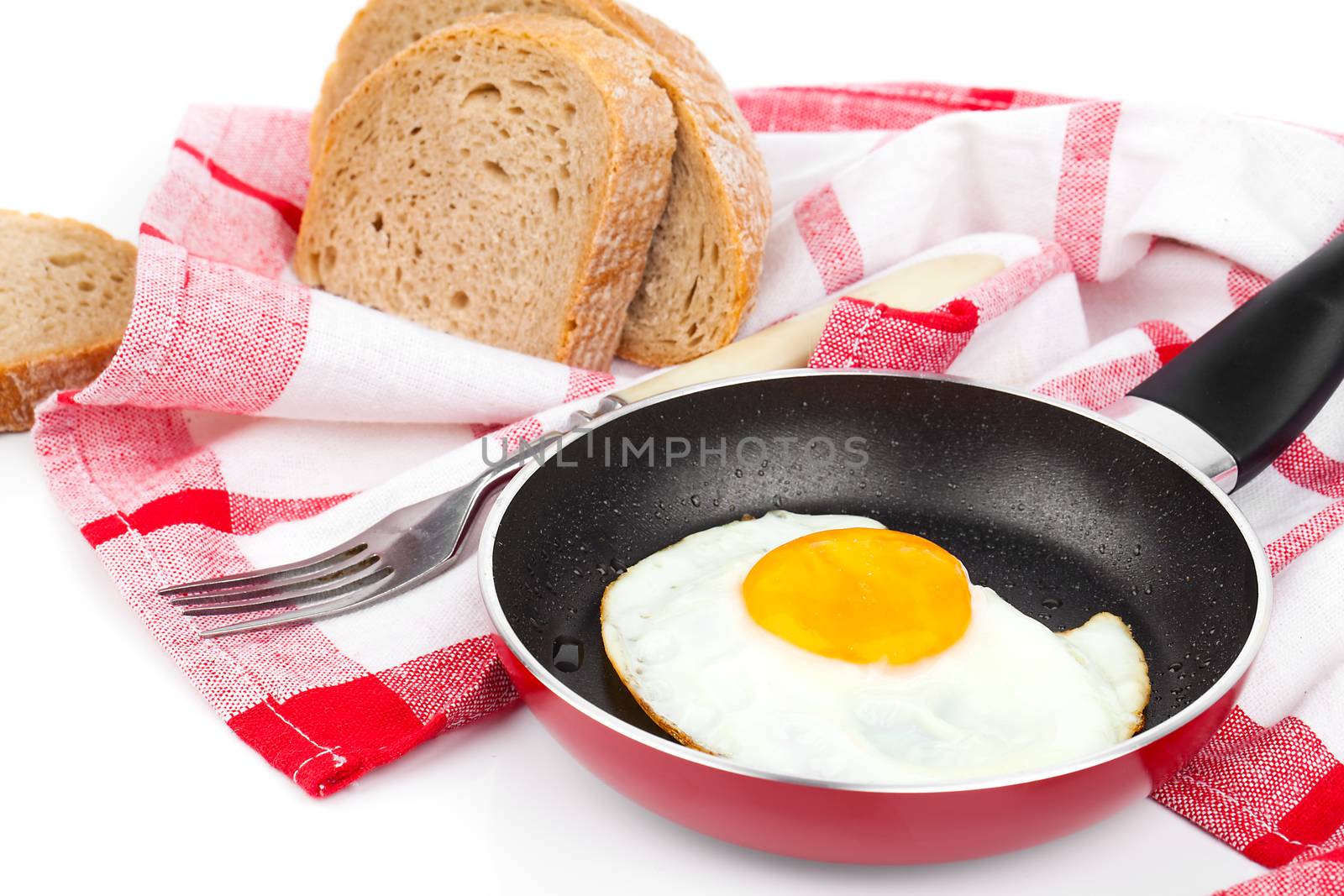 Fried egg in a frying pan, over white background