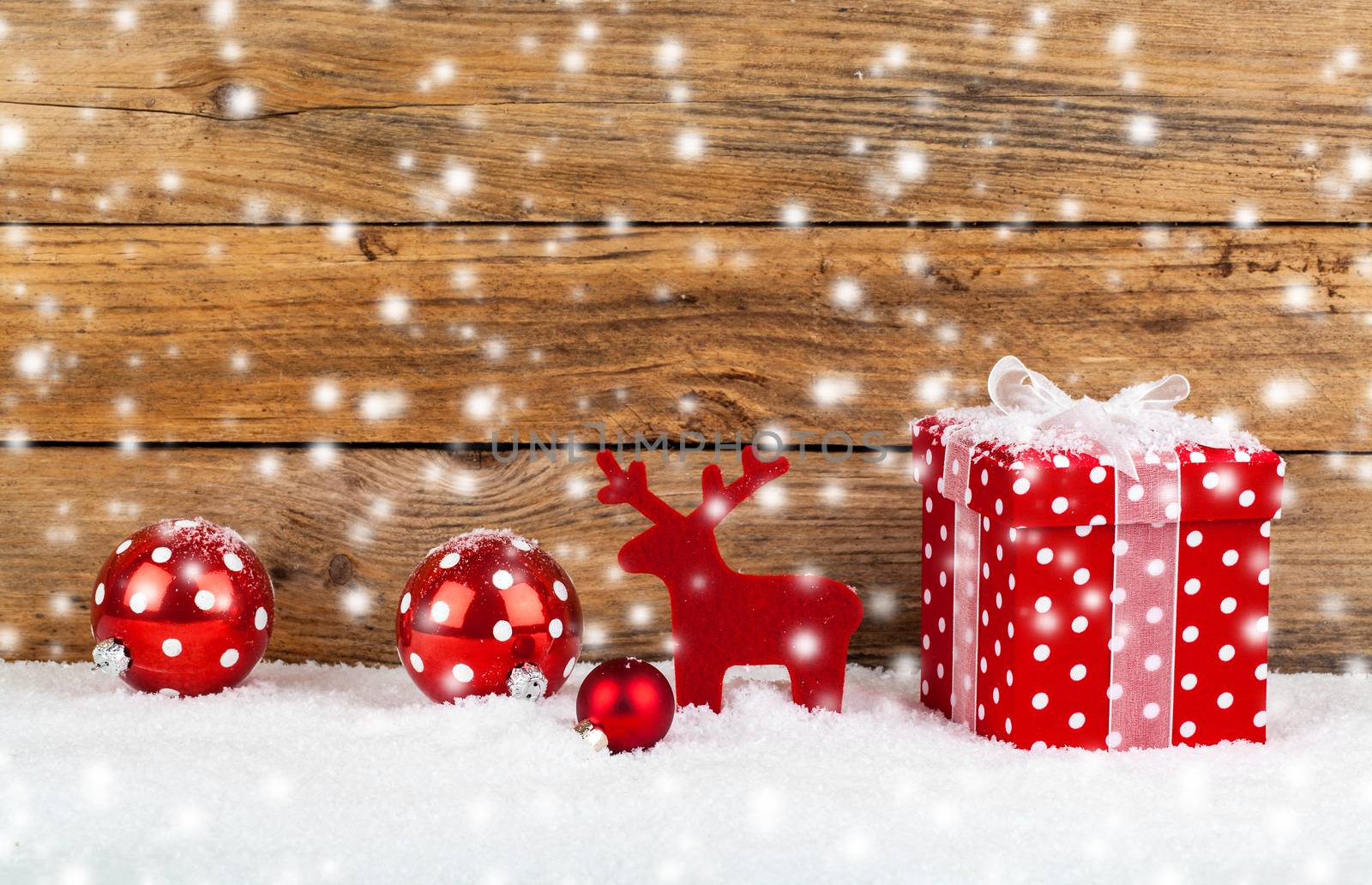 red gift for christmas on a wooden background with snow