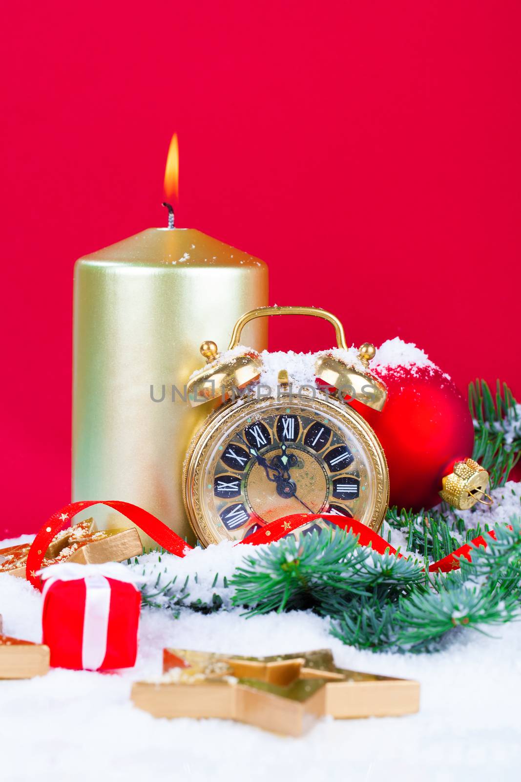 Christmas decorations - clock for the new year, candle, pine branch on orange background