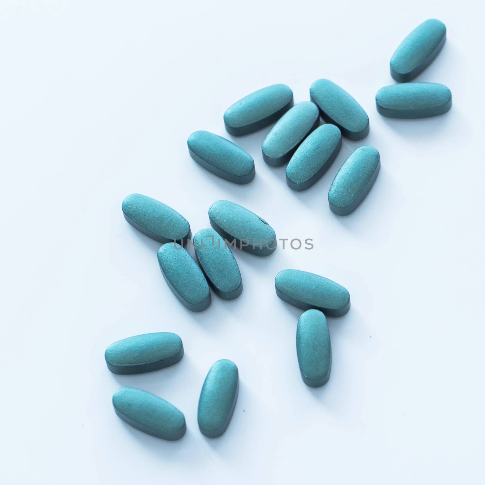 Closeup picture of blue pills over a white background