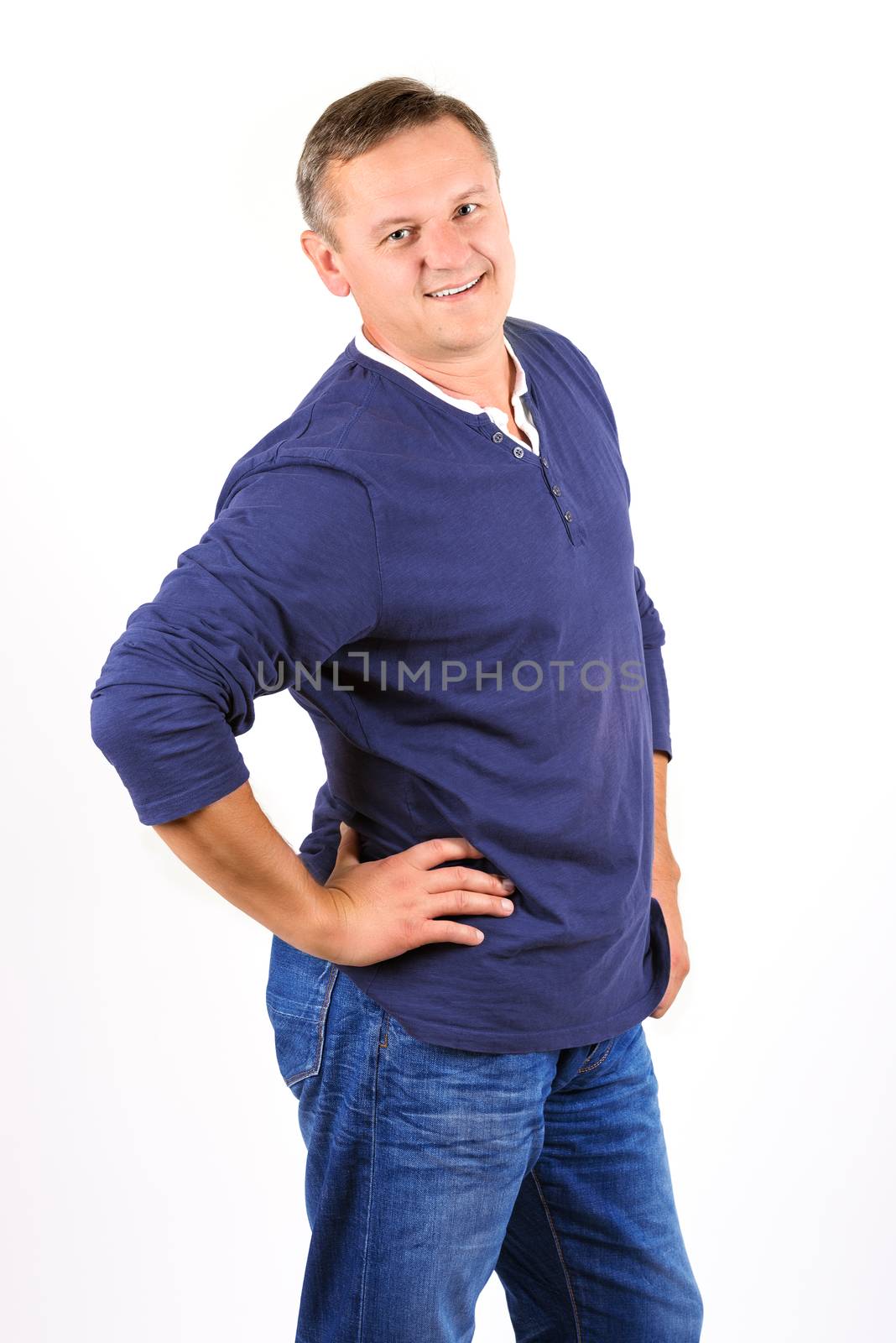 Casually dressed middle aged man smiling. 3/4 view of man shot in vertical format isolated on white.