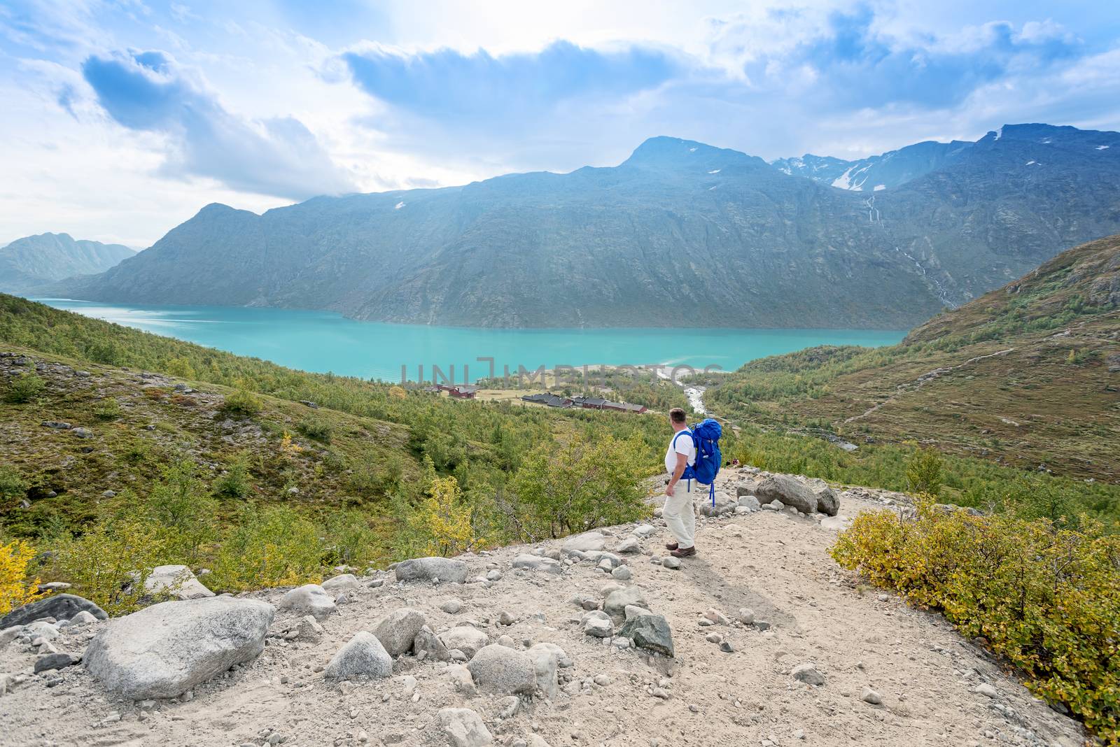 Lone traveler looking at mountain lake