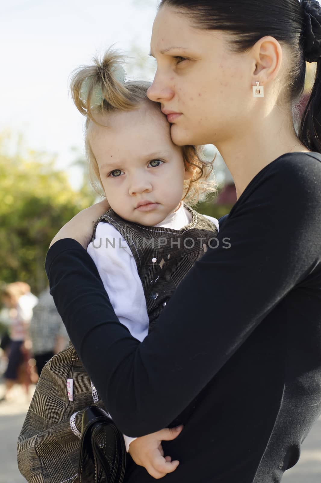 Mother is in the hands of a child in a crowded place