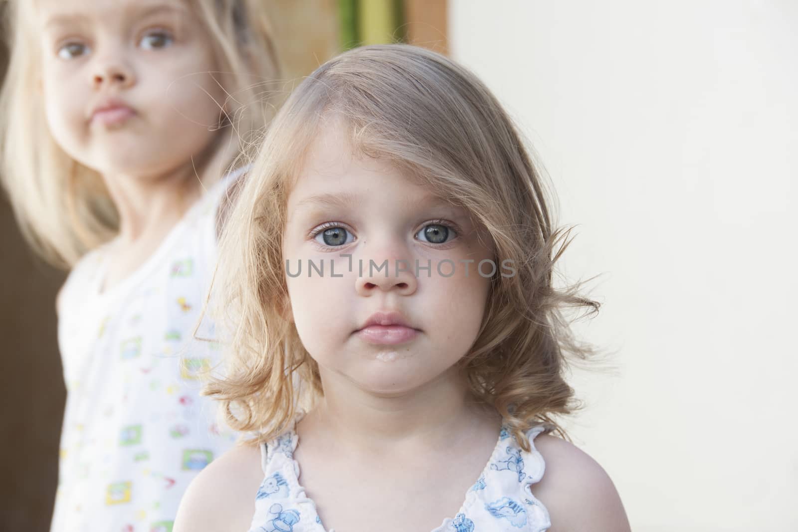 Portrait of two girls: four-year-old girl in the background, two-year at the front