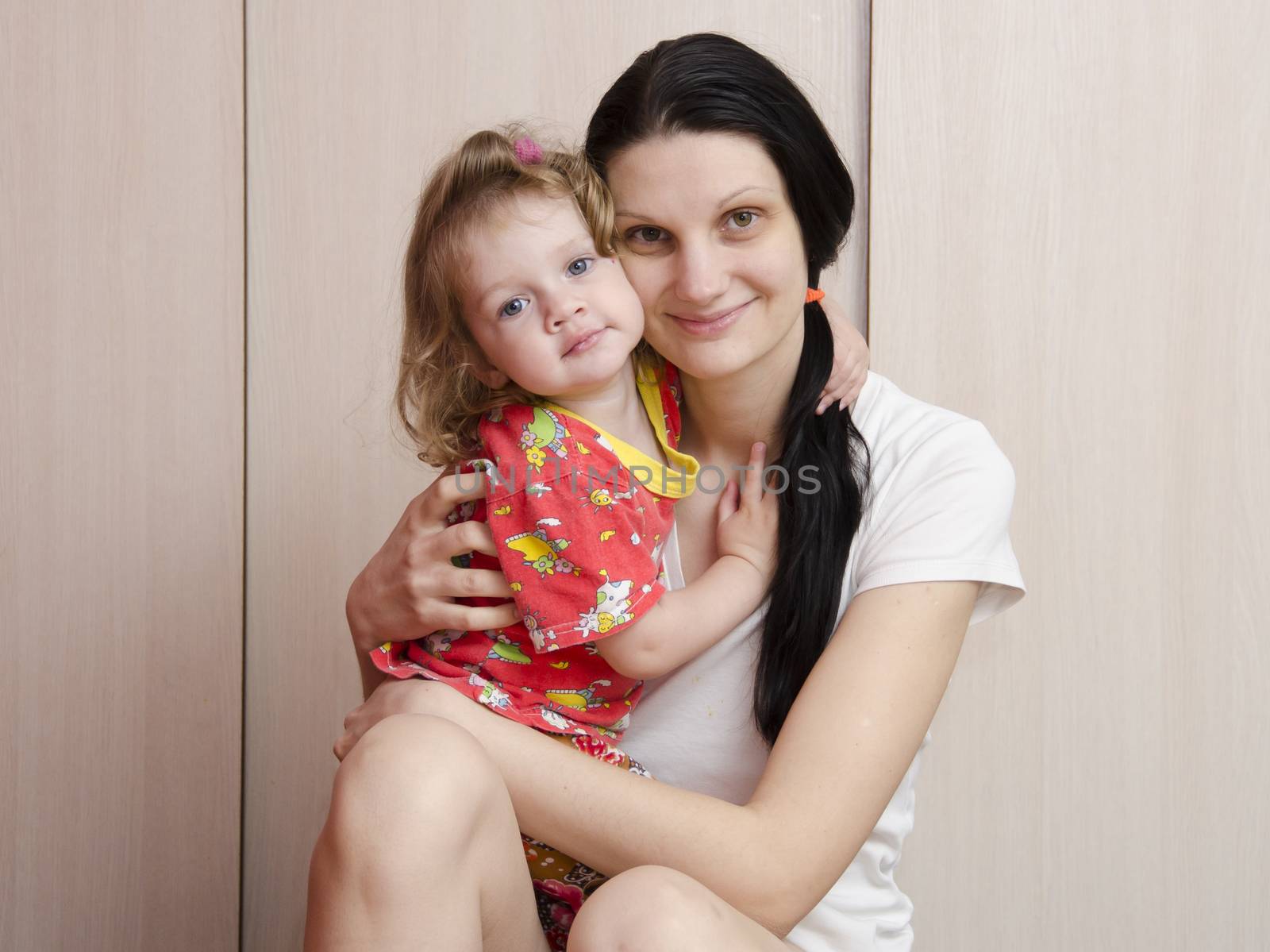 A happy mother and daughter at home cuddling and watching the frame