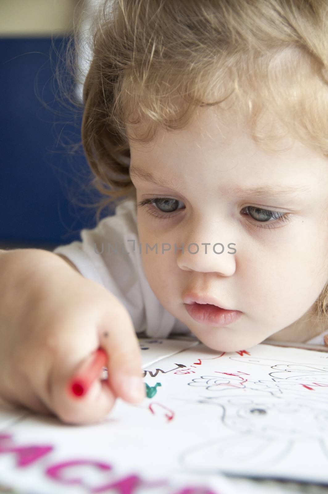  Girl draws a pencil in ??????????. The girl looks carefully at the tip of a pencil. Closeup