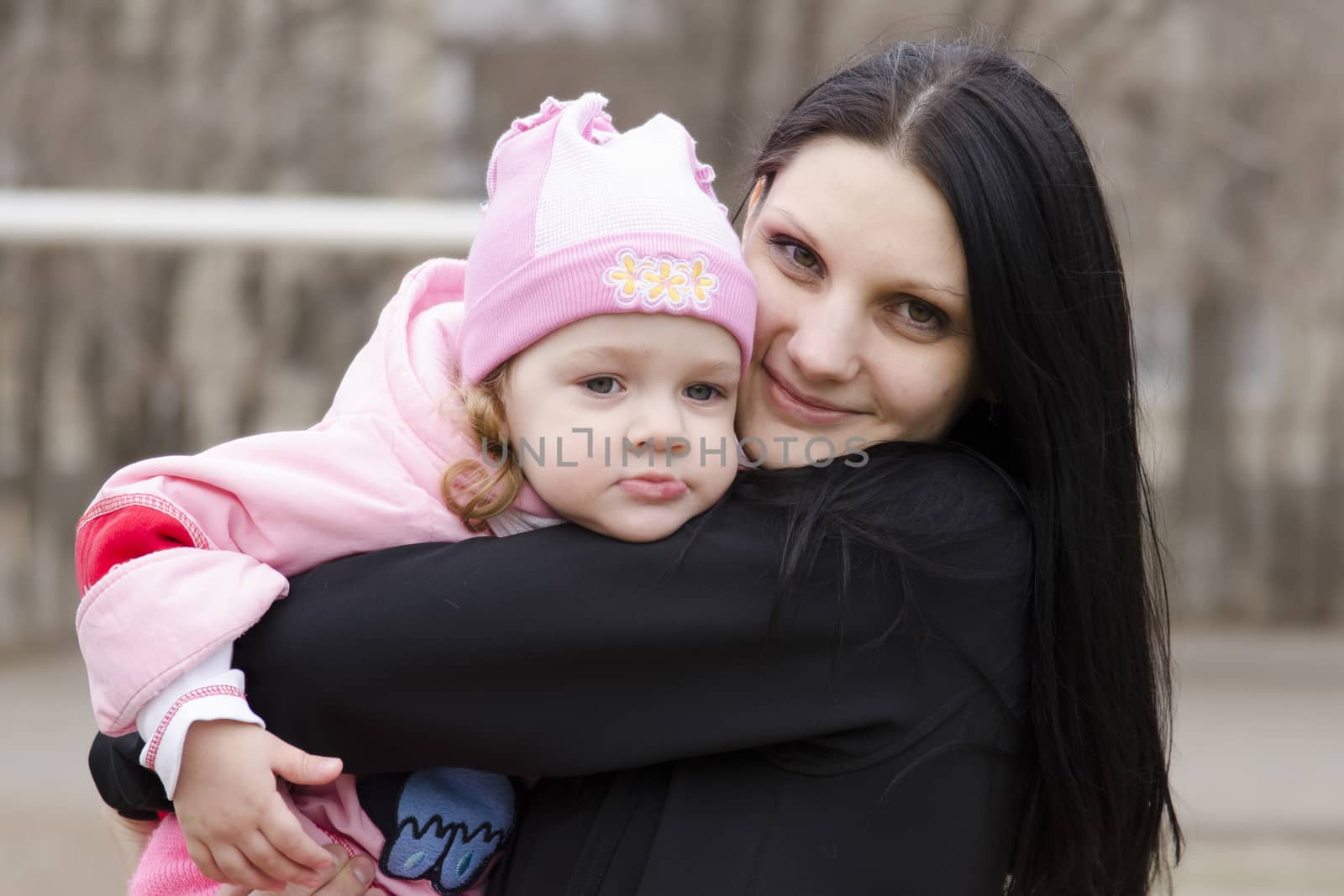 Little girl keeps mum on his hands. The girl thoughtfully laid her head on her mother's shoulder. A warm spring day.