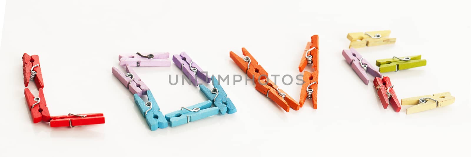 Love from little colorful office clothespins isolated on a white table