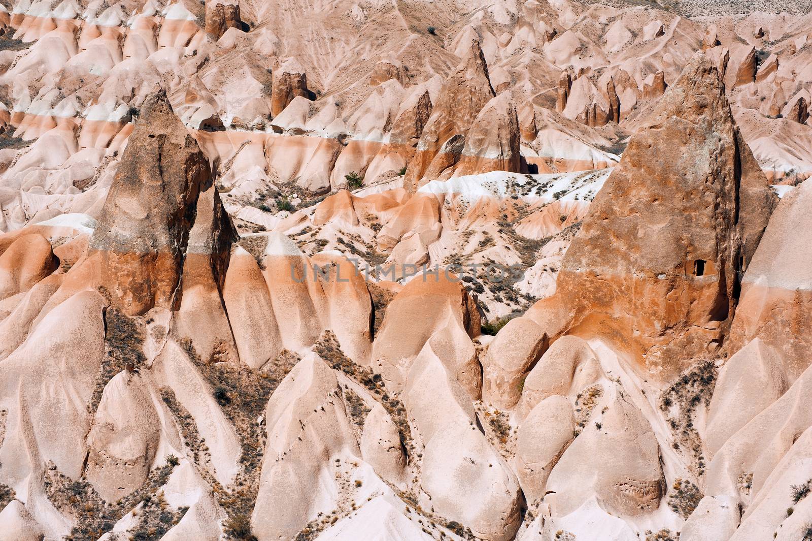 Detailed photo of vivid pink rock formations with caves from above in Cappadocia, Turkey