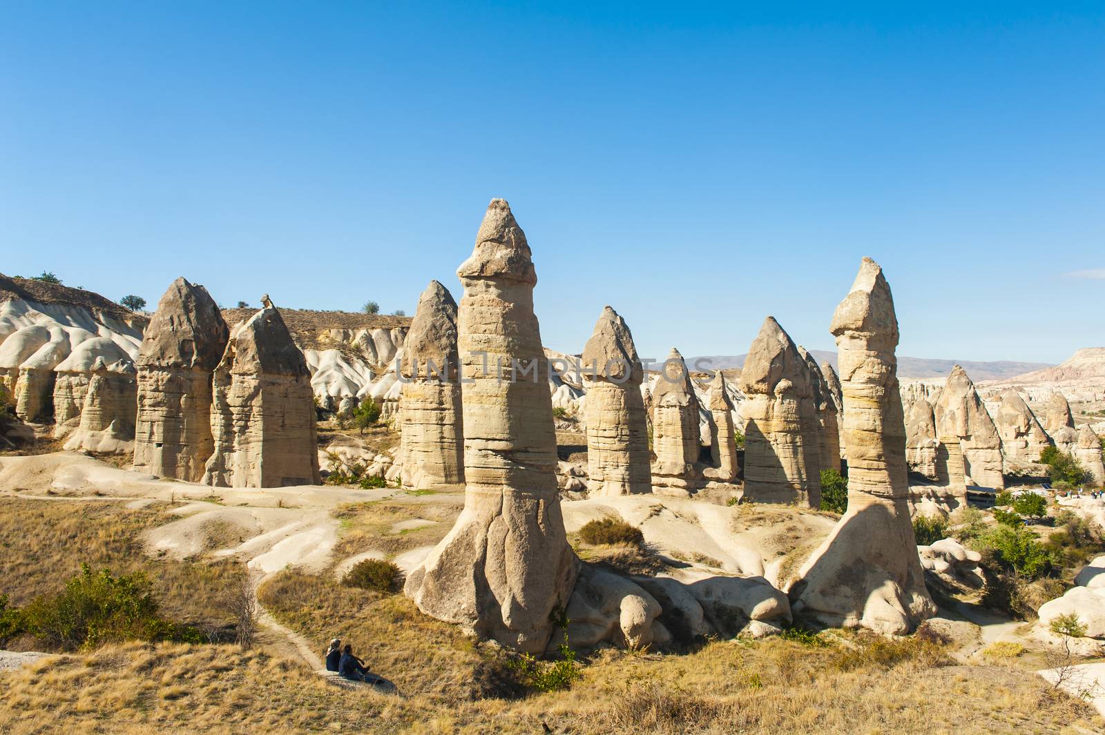 Two unrecognizable tourists watching fairy tale chimneys near Goreme, Cappadocia, Turkey
