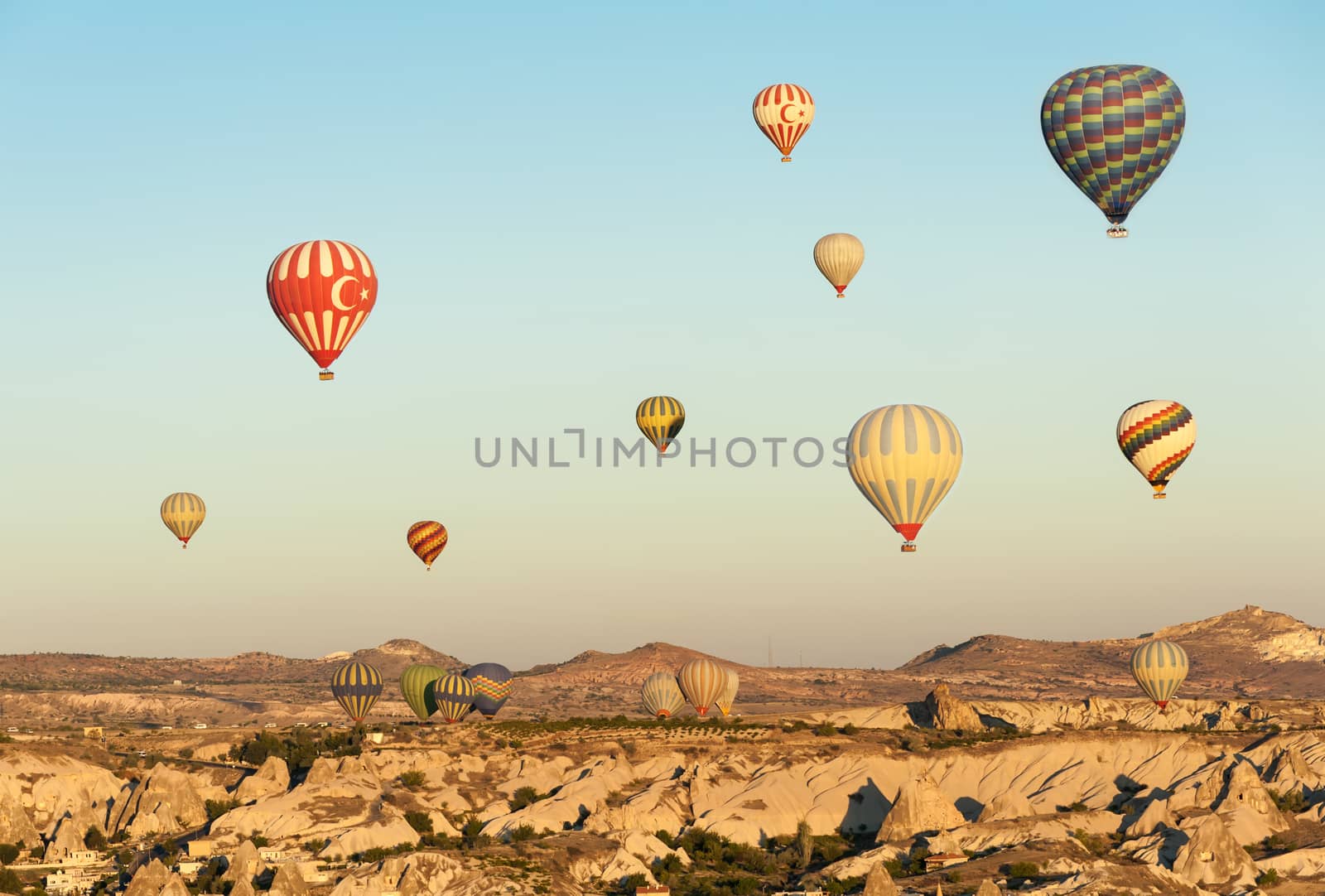 Hot air balloons flying over Cappadocia near Goreme at sunrise, Turkey