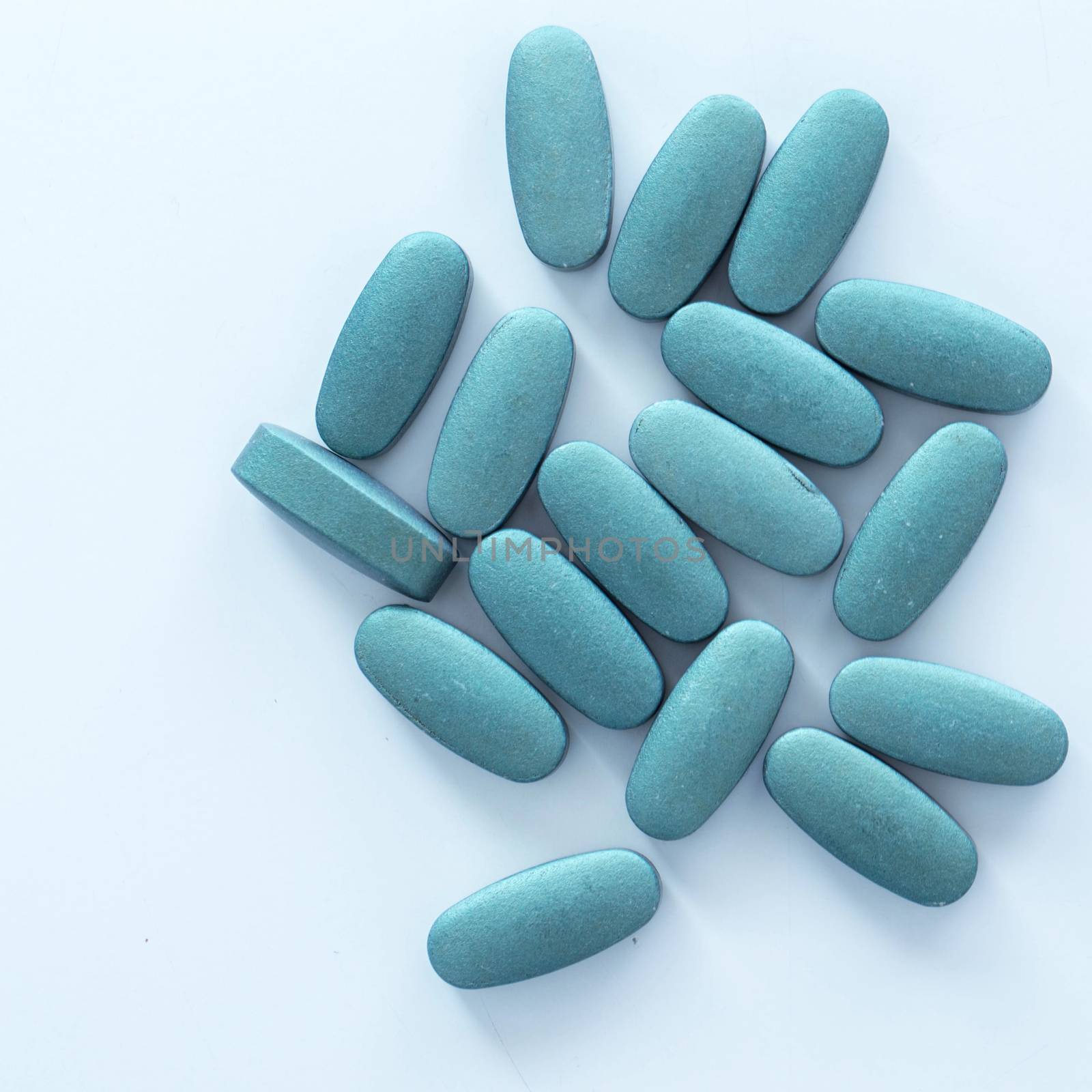 Closeup picture of blue pills over a white background