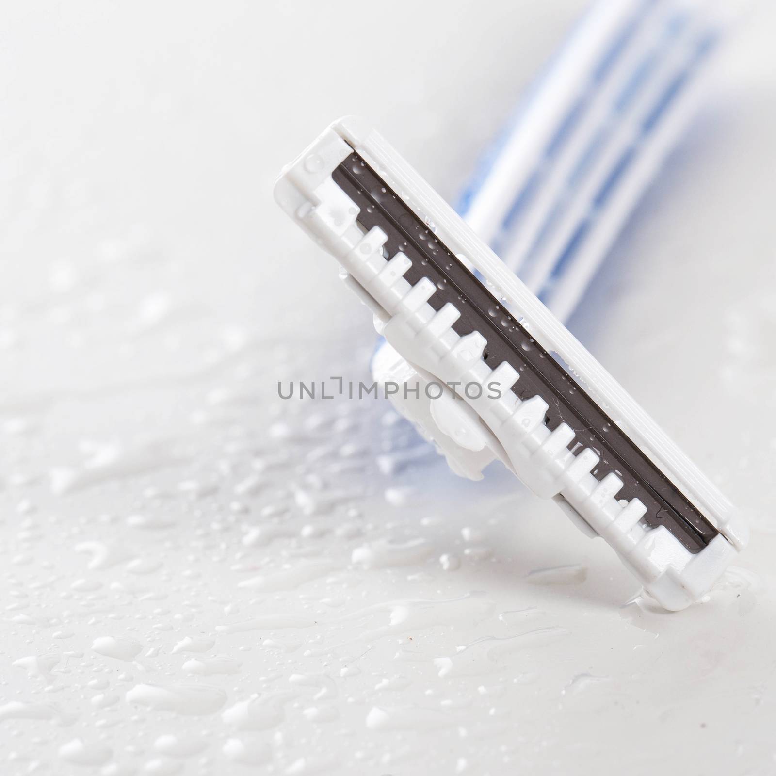 Picture of white and blue razor for men over a white background