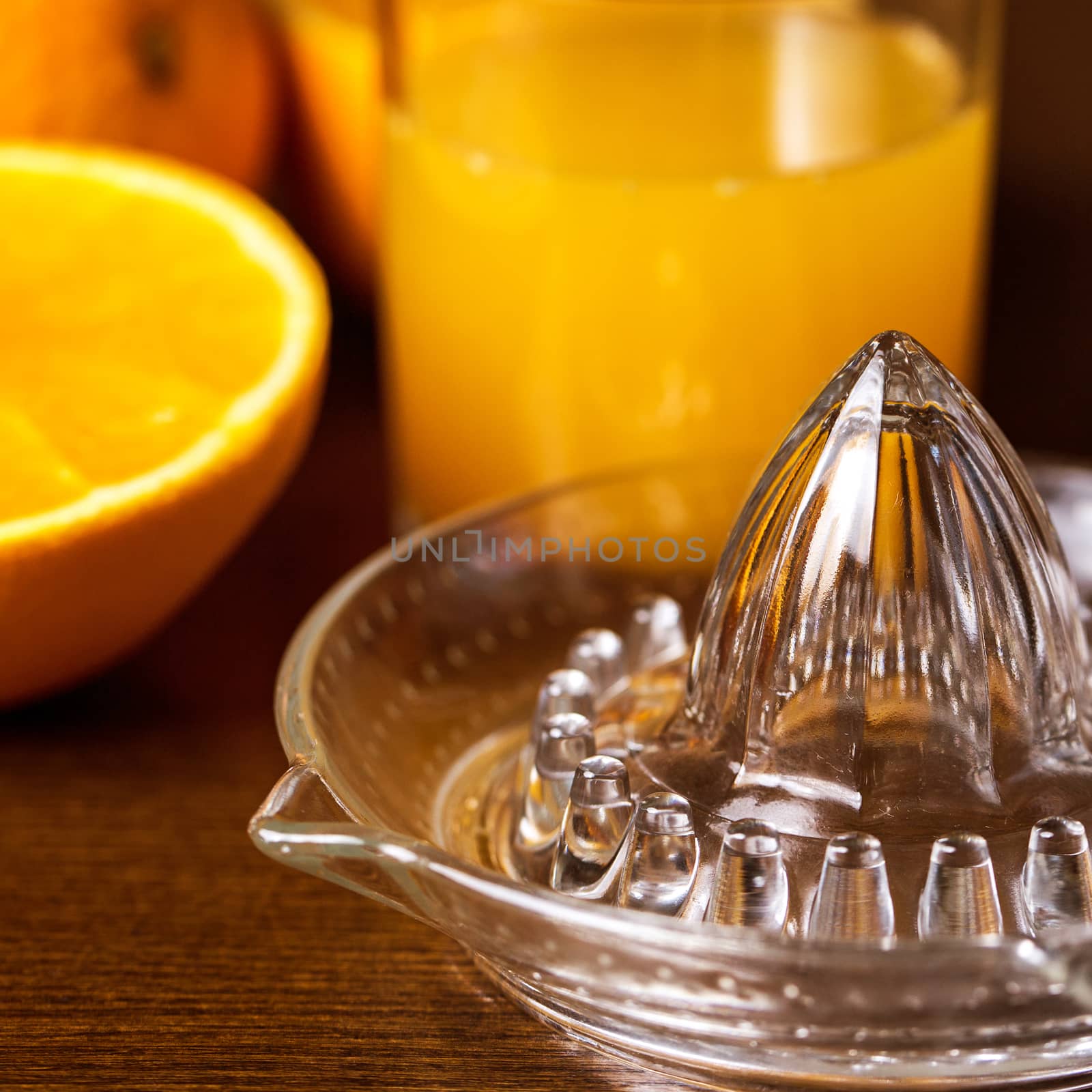 Oranges and a glass of orange juice on a wooden surface