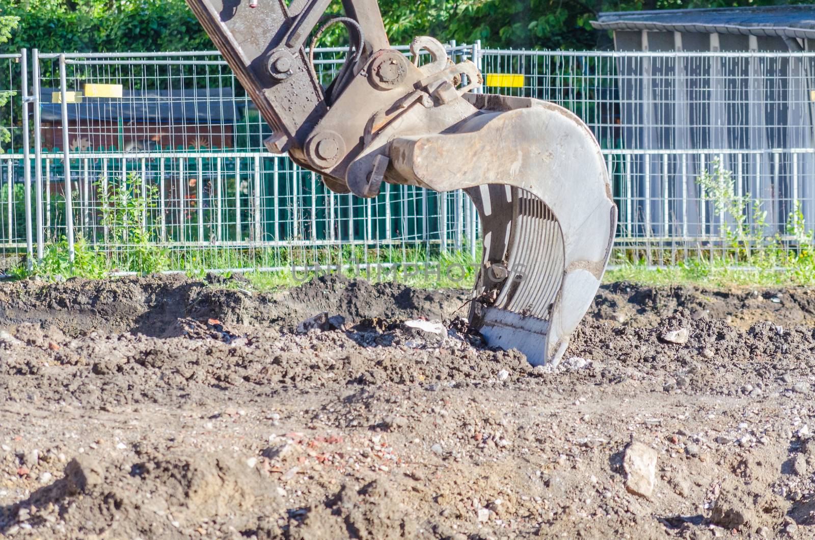 Large excavator shovel in use in earthworks on a building site.