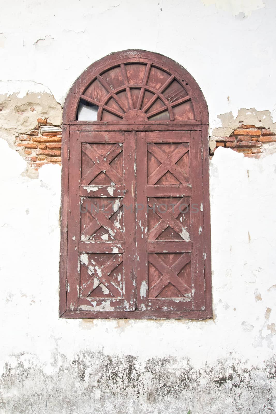 Old ancient brown window on damage wall by eaglesky