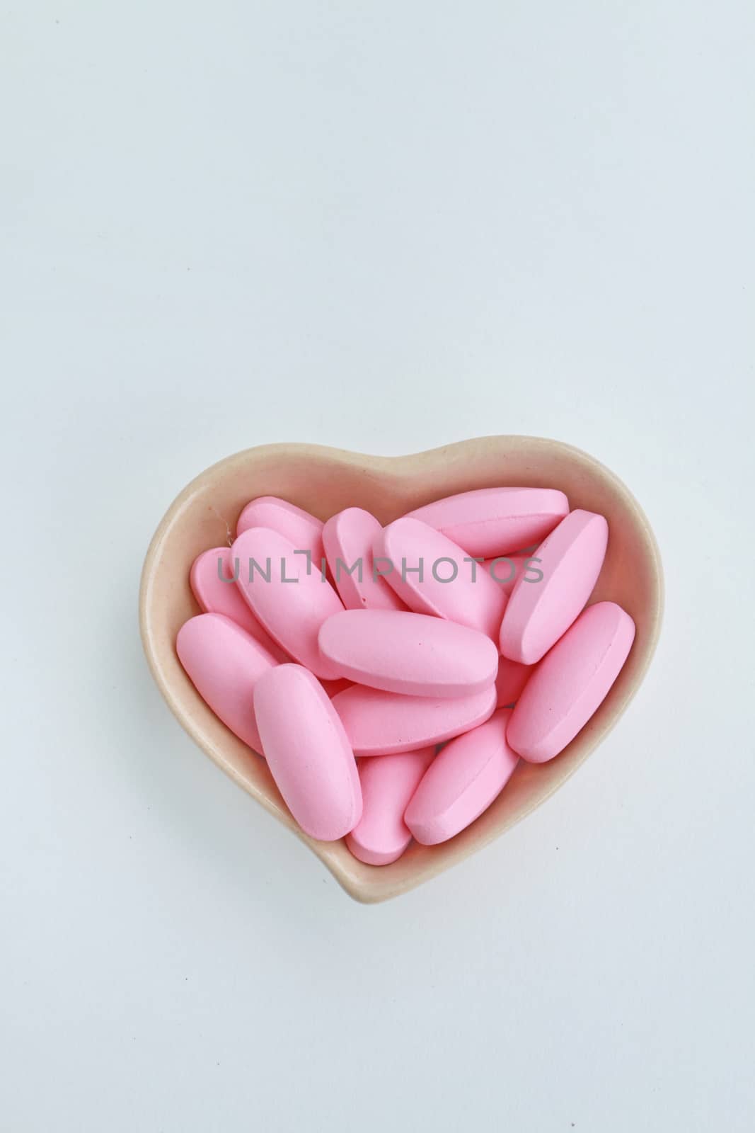 pink oval pills in the cup shape of heart2 by kaidevil