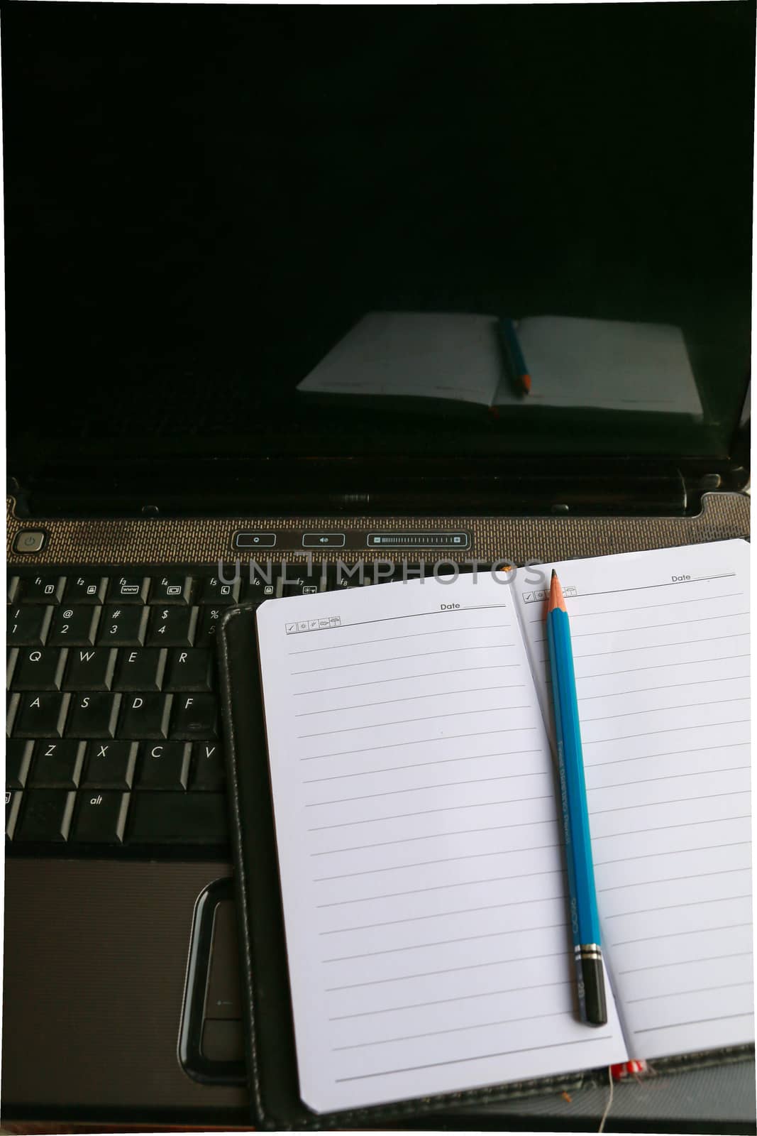 There are writing tools on the keyboard of computer laptop to prepare for work.