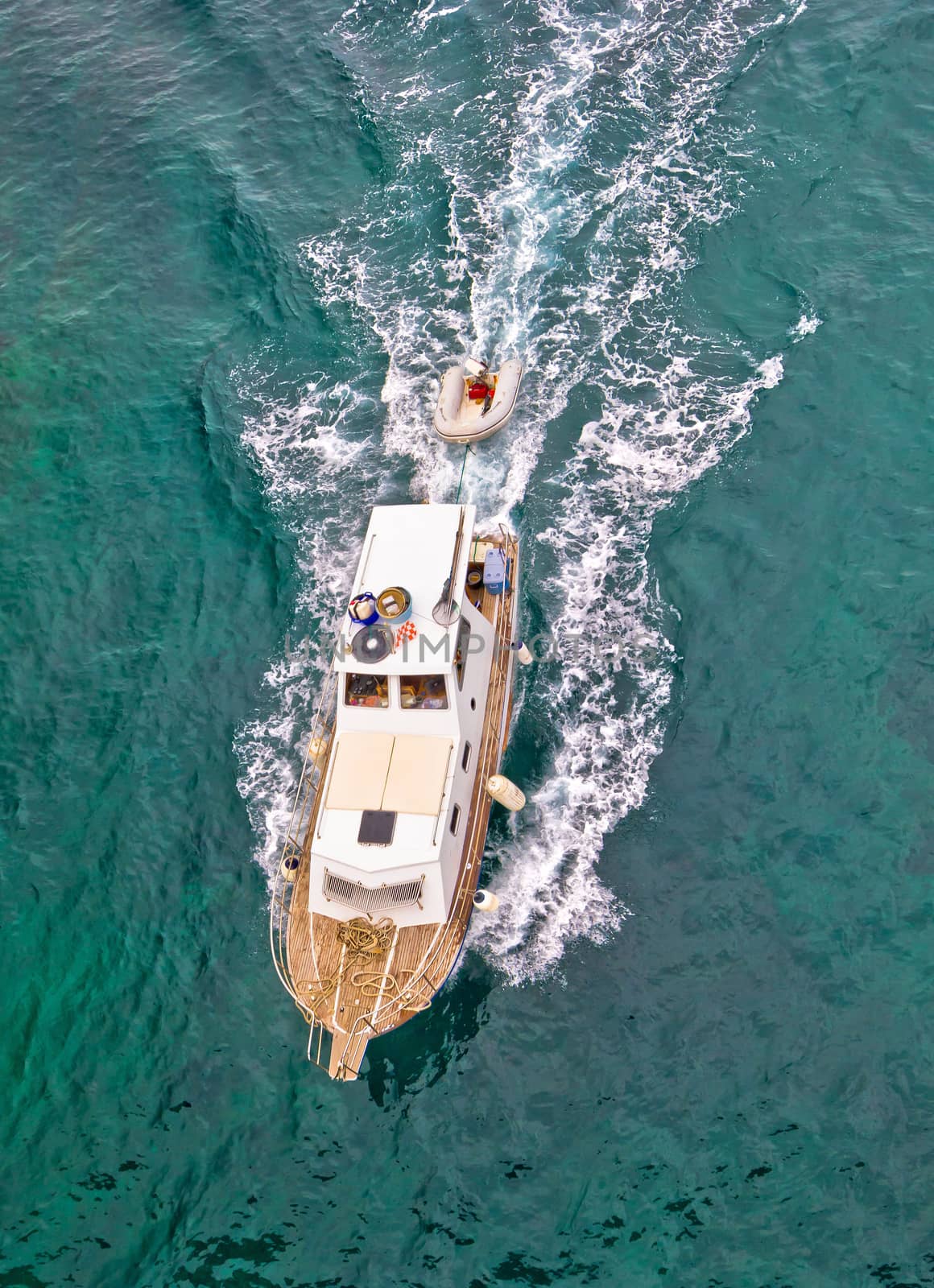 Fishing trawler on blue sea aerial vertical view