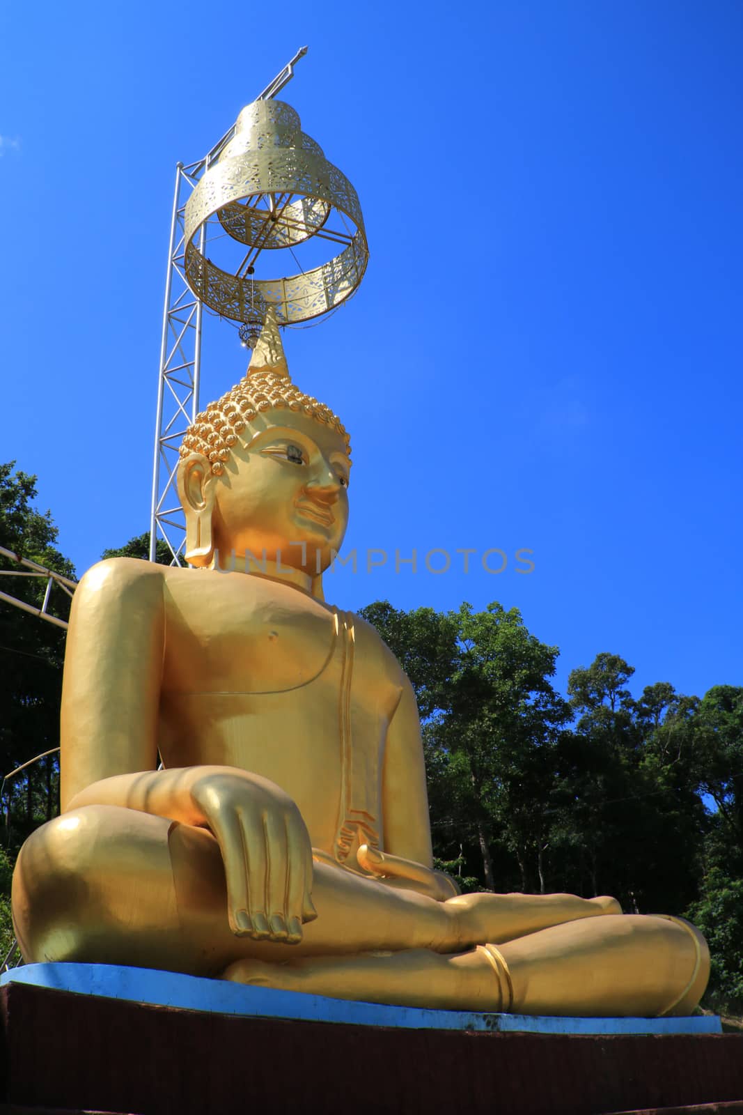 The golden image of Buddha which have Thai art umbrella over the head.