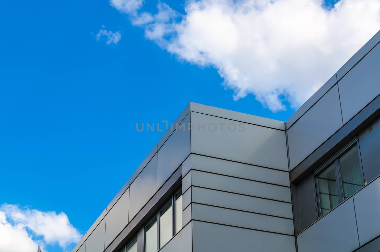 Cloud game, a house facade in front of a blue Hhimmel with white clouds.
