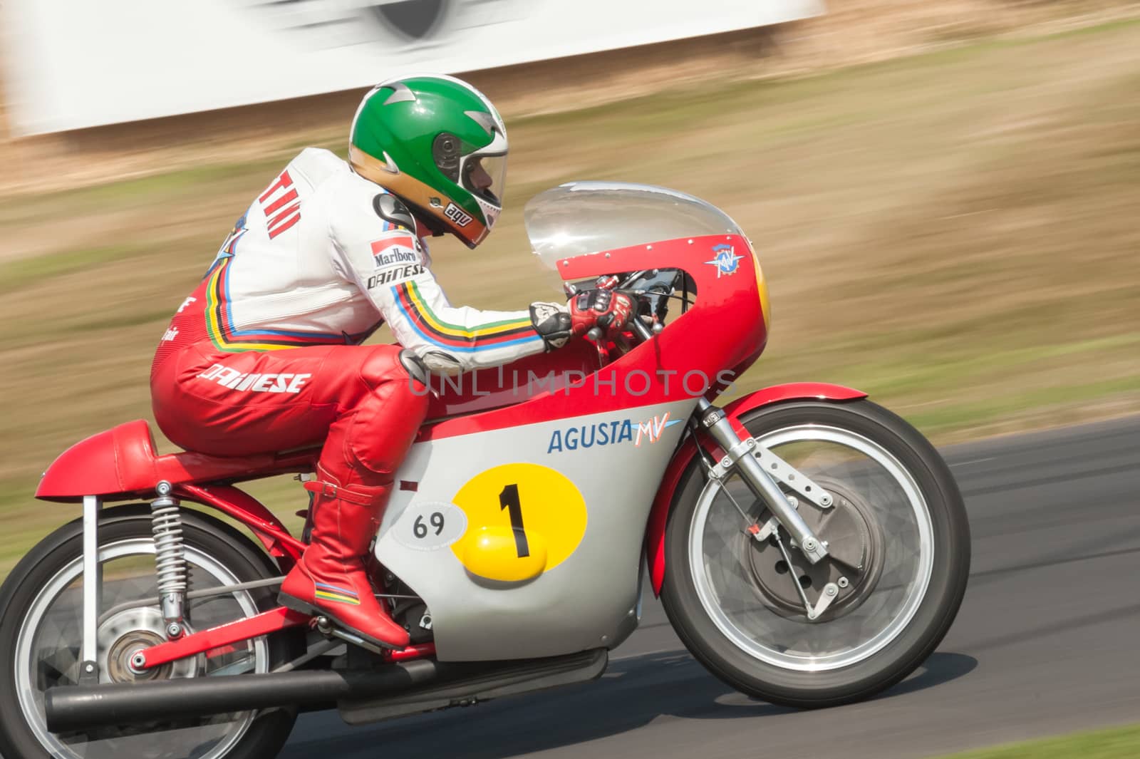 Goodwood, UK - July 13, 2013: Fifteen times motorcycle world champion Giacomo Agostini riding his classic MV Agusta motorcycle at the Festival of Speed event at Goodwood, UK