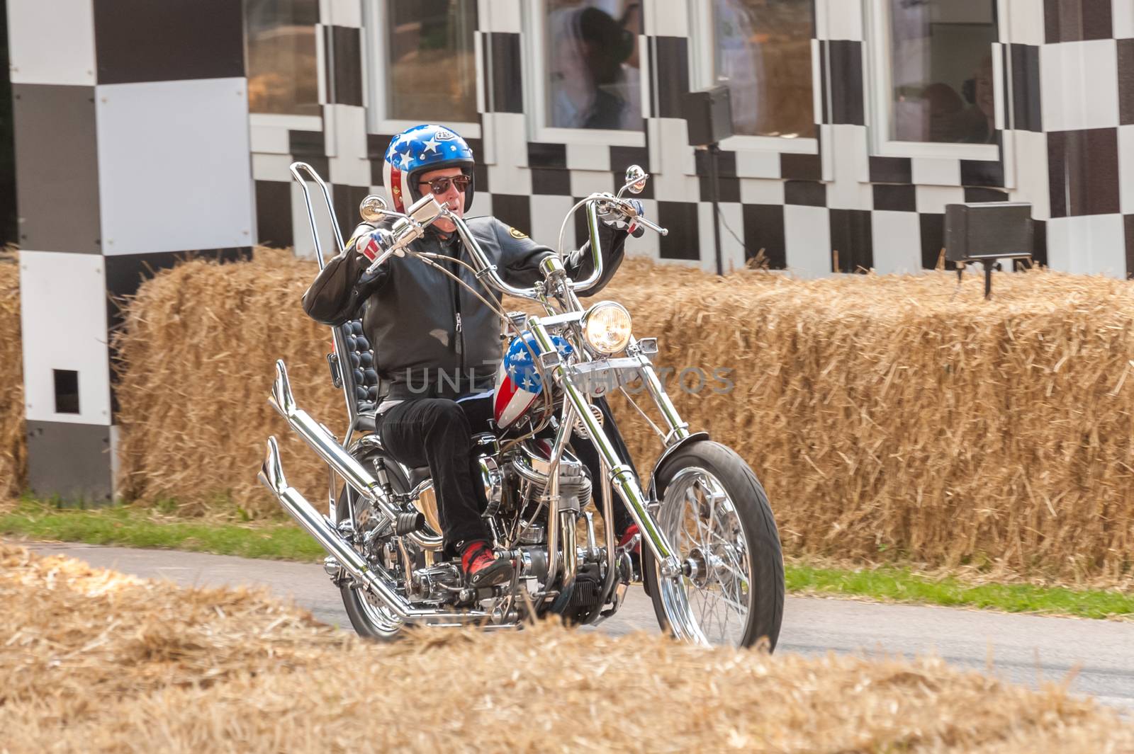Goodwood, UK - July 13, 2013: Hollywood actor Peter Fonda on an iconic Captain America chopper motorcycle from the movie, Easy Rider at the Festival of Speed event, held at Goodwood, UK