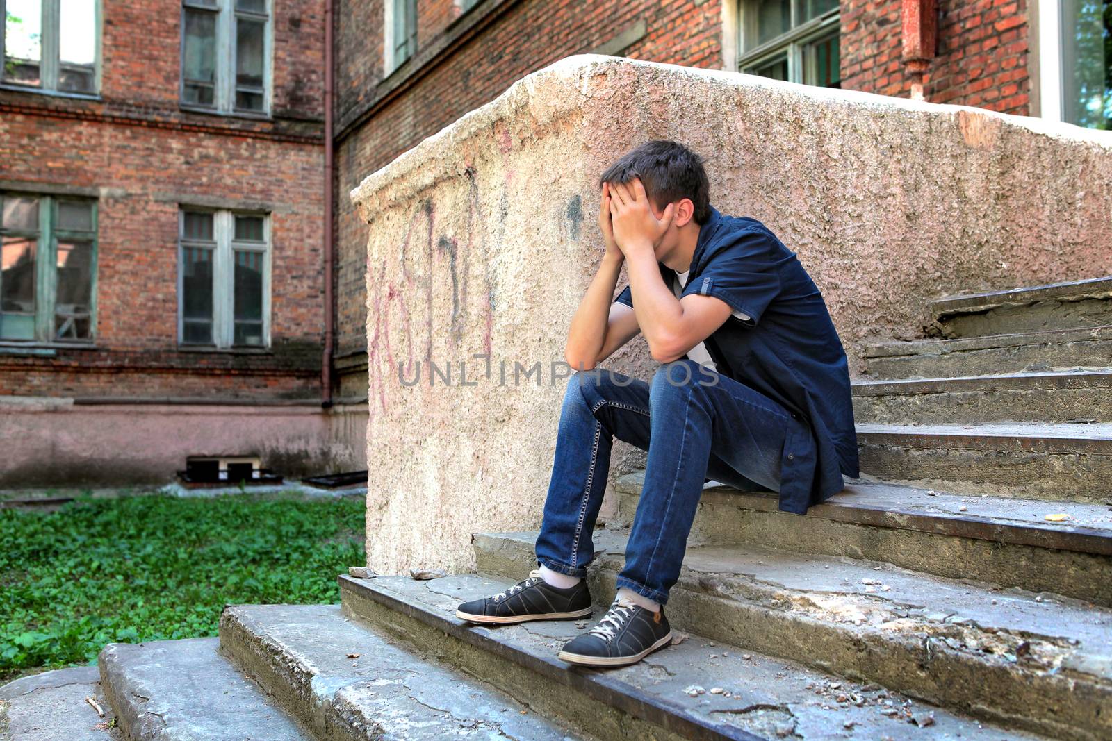 Sad Teenager on the landing steps of the Old House