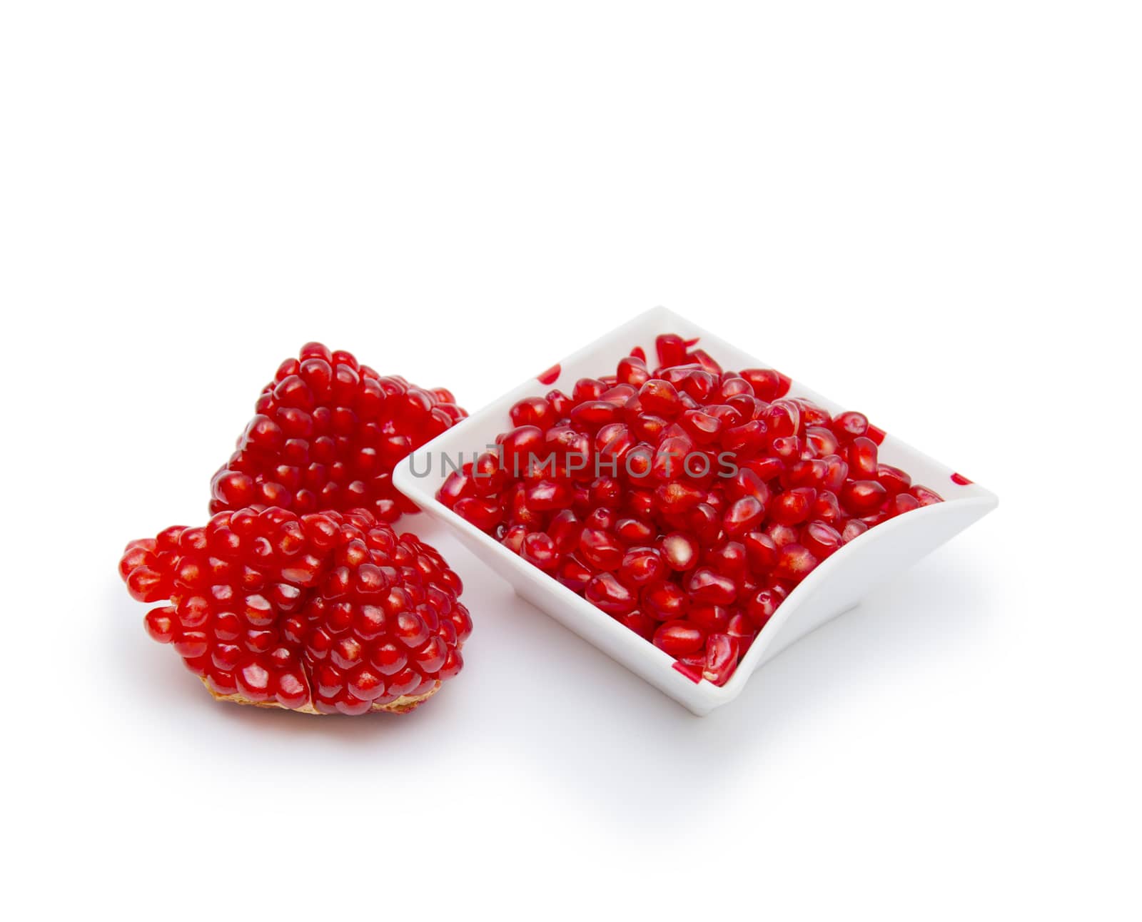 Loose pomegranate seeds in a white bowl