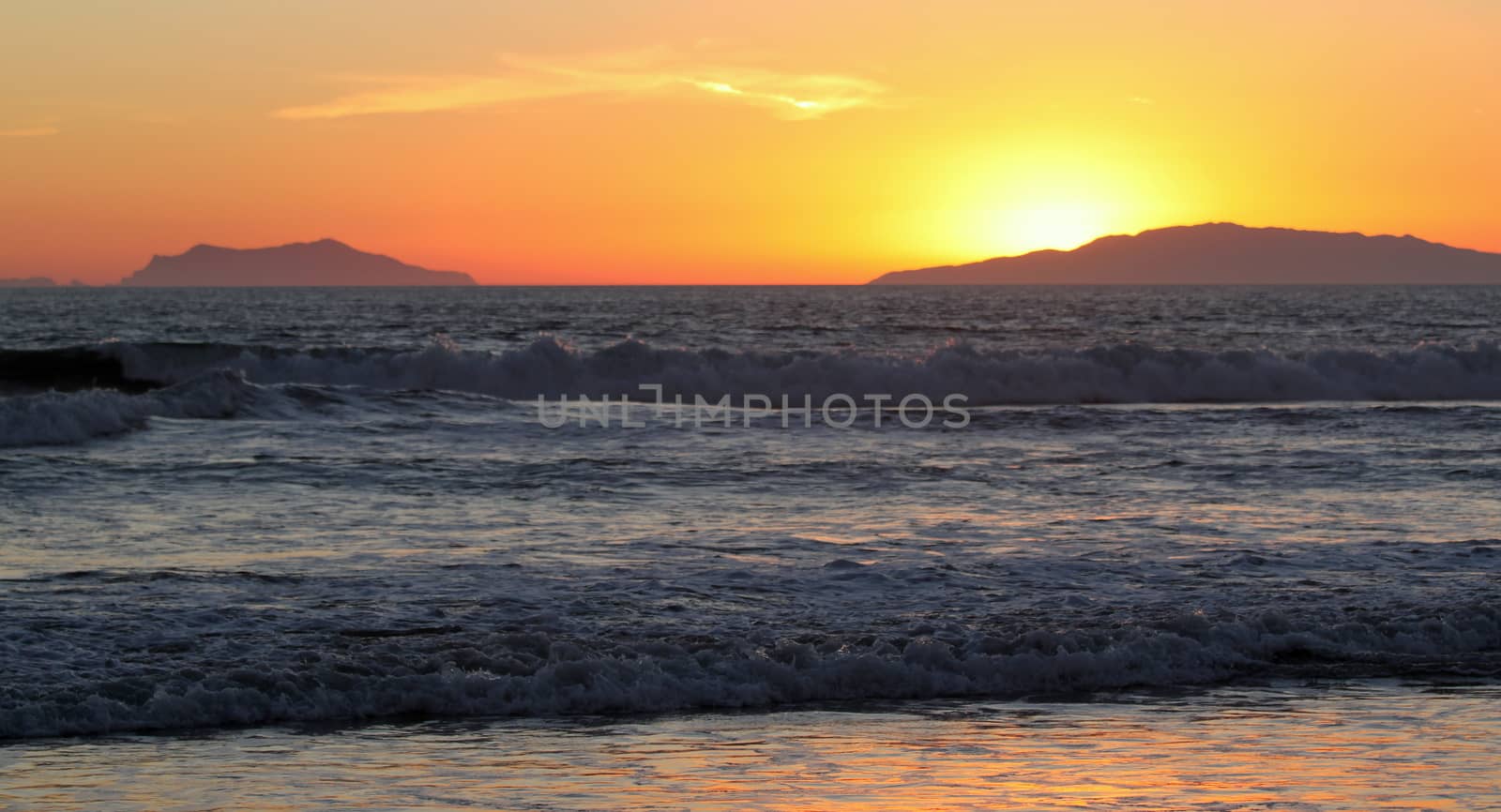 Sunset over the ocean with an island in the background